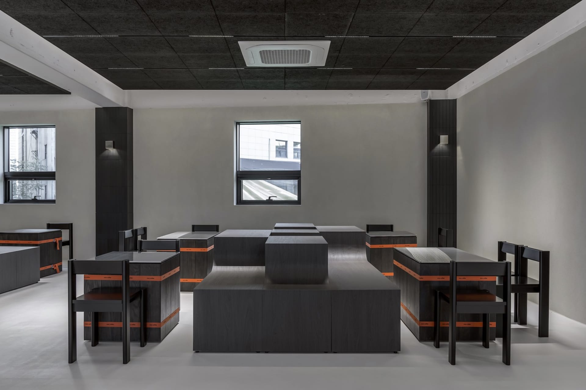 A professional office space with multiple modern desks and chairs, arranged in rows for a sense of organization and functionality
