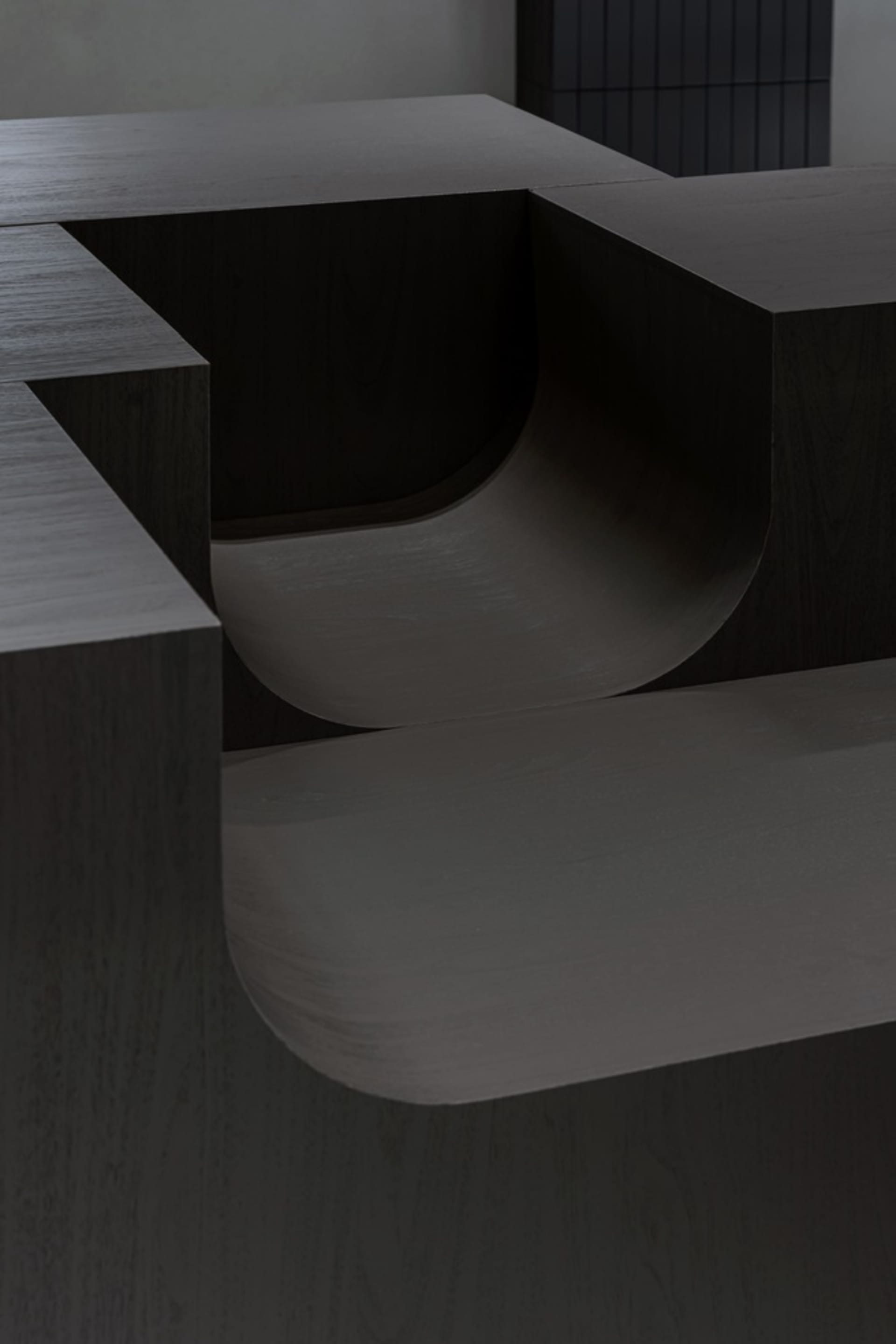 A dark wooden table with two curved benches forming an L shape, creating a cozy and intimate atmosphere