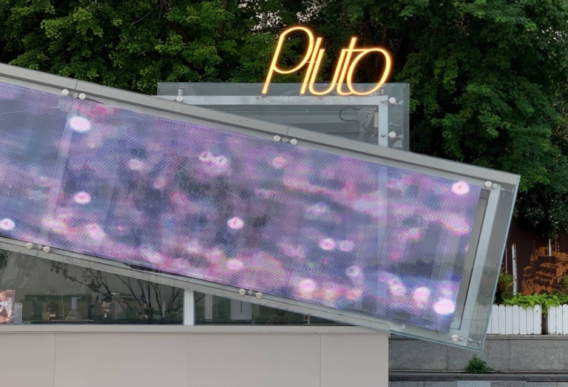 Large commercial building with a glass facade, white and grey tones, and a sleek modern design