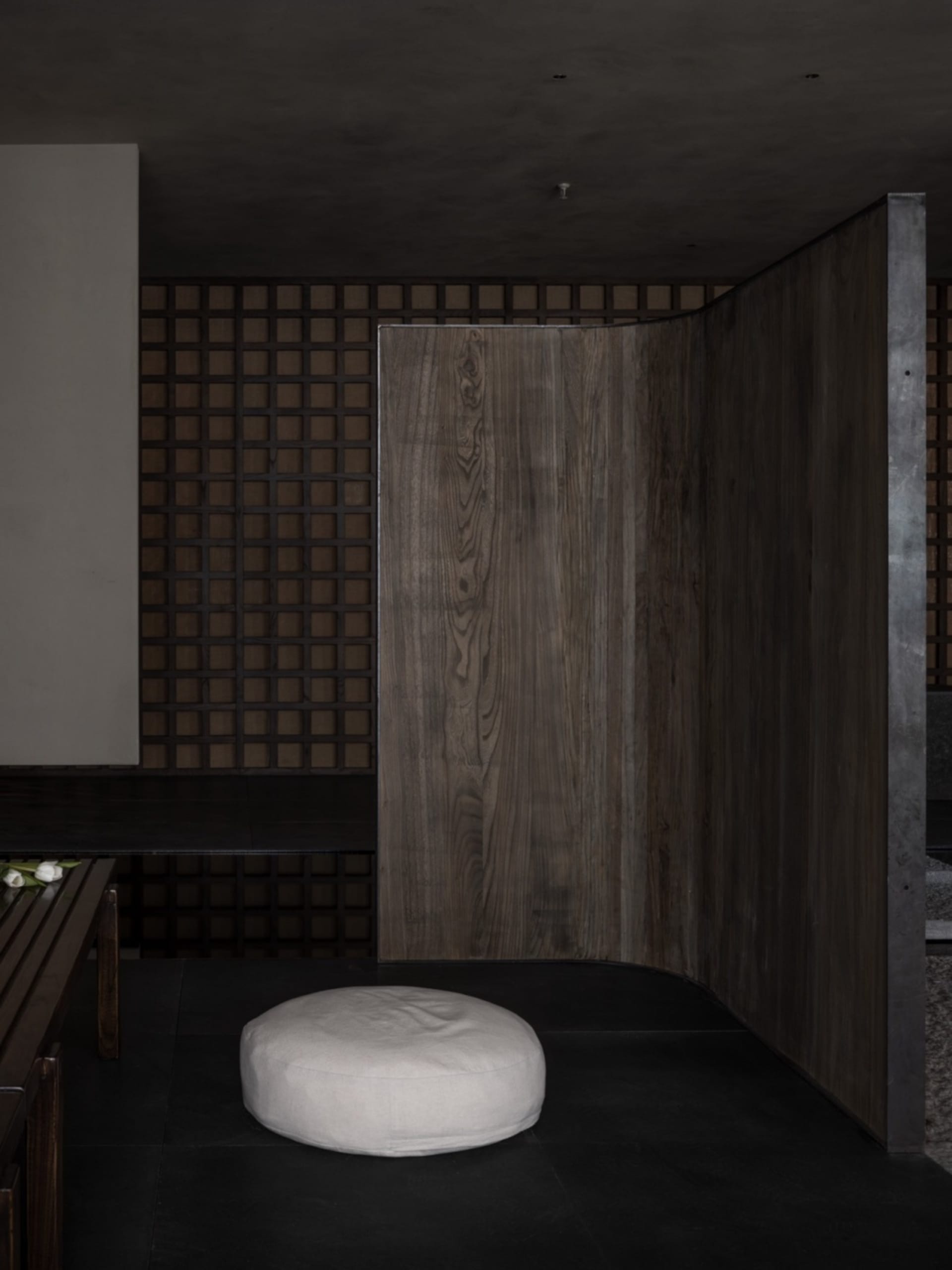 Warm and inviting room with a wooden floor, wooden doorway, and two benches, with a chair placed in the center