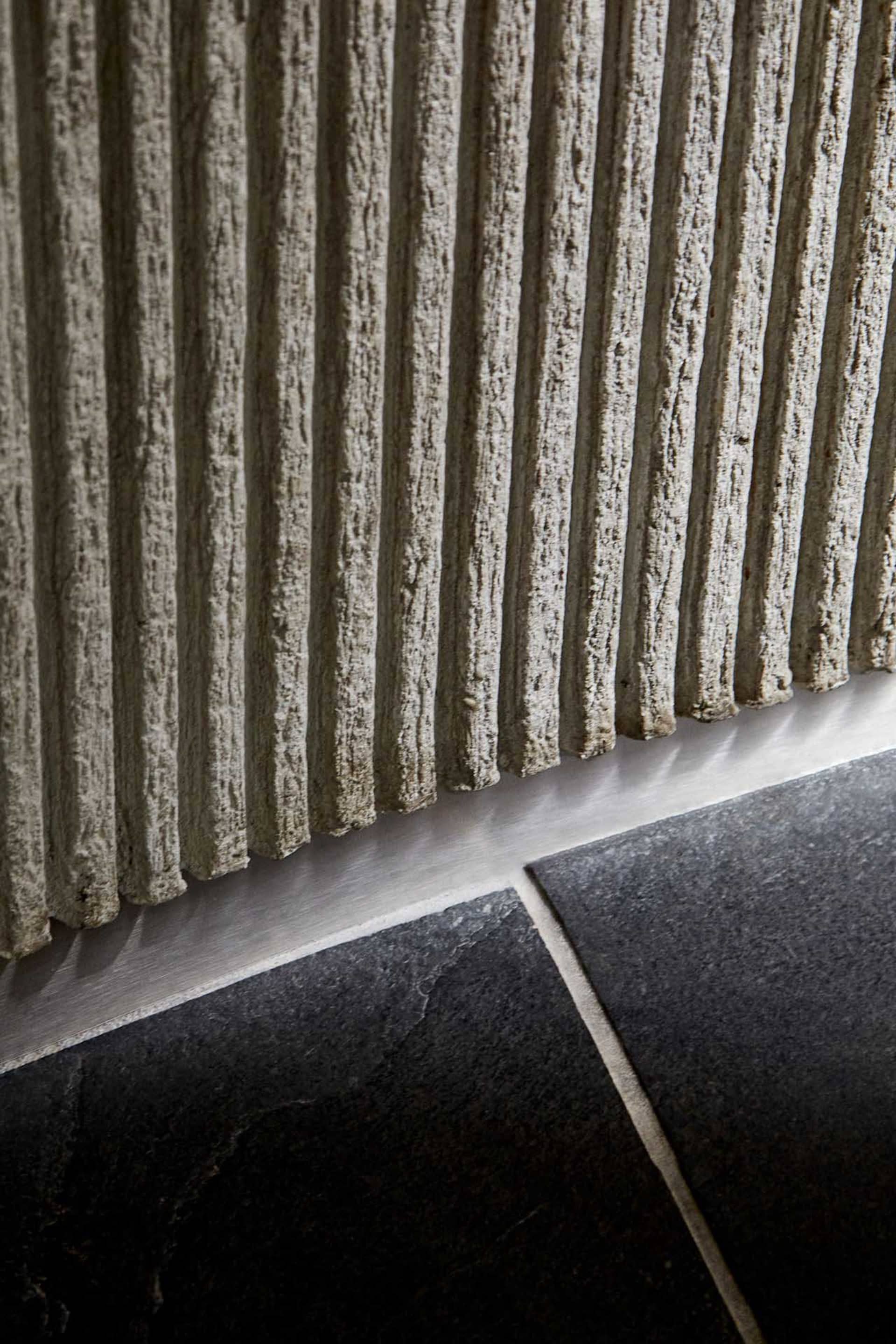 A bathroom with a white tile wall featuring a striped pattern, creating a clean and well-maintained atmosphere with a focus on functionality and simplicity