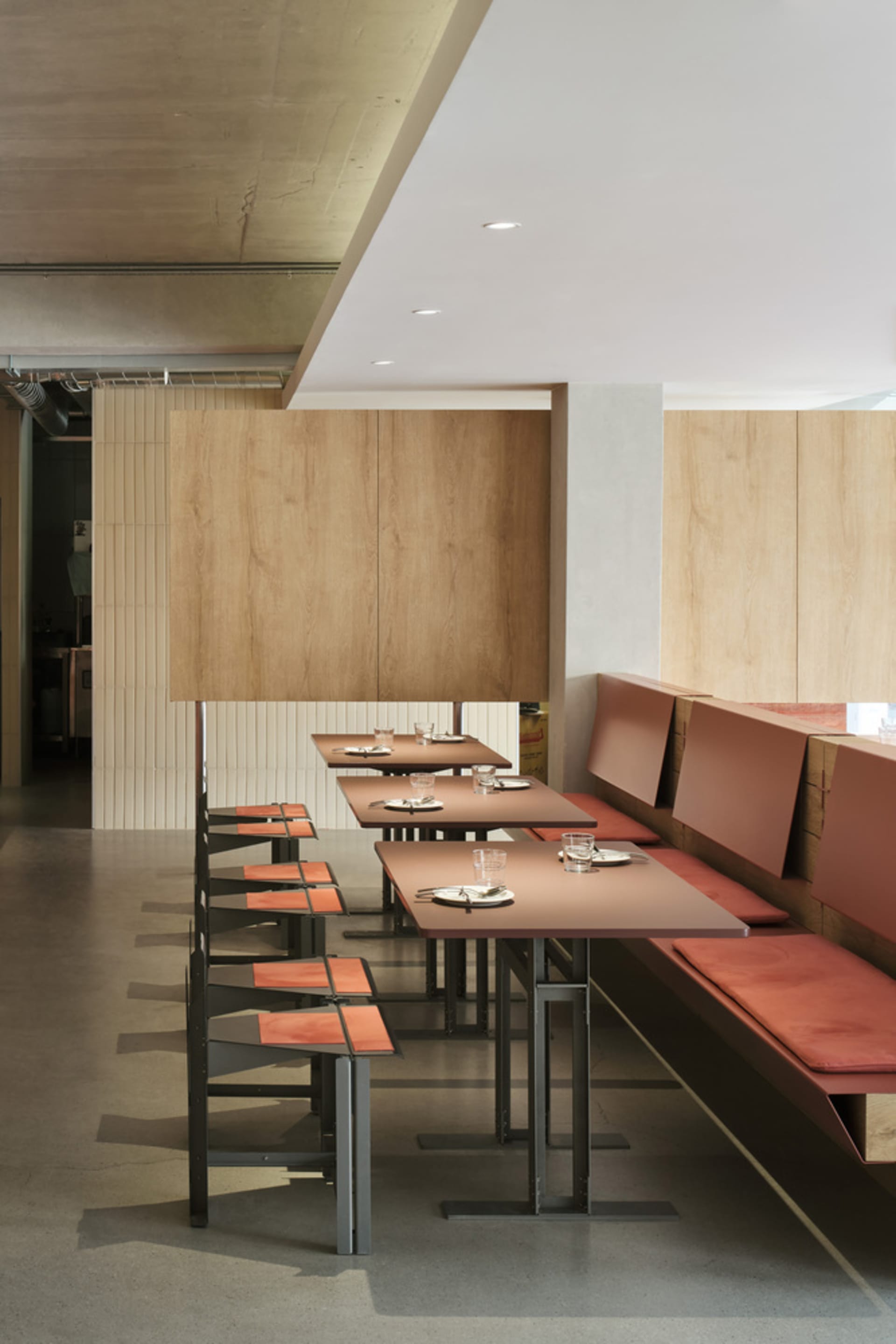 Warm and inviting restaurant interior with wooden walls, multiple dining tables, and comfortable seating options