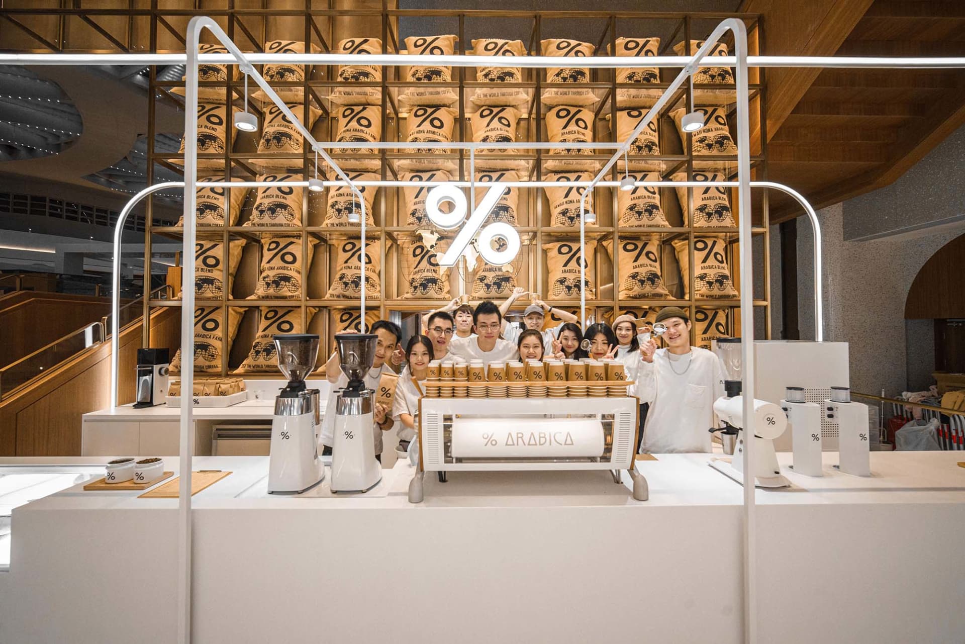 一群人圍繞在咖啡店展示區前，展示各種咖啡豆包裝，營造出友善而溫馨的氛圍