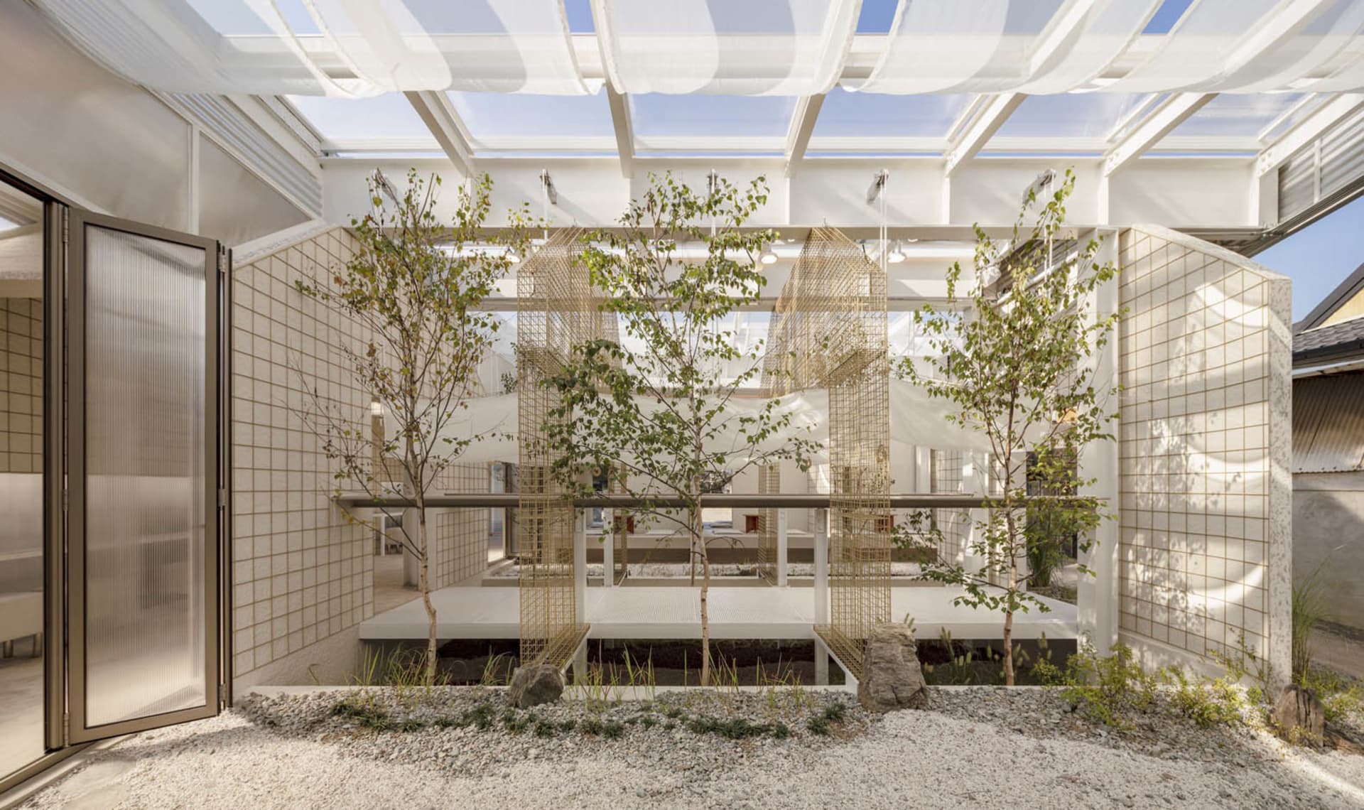 A cozy indoor space with a mix of living and garden areas, featuring potted plants, a dining table, and a couch, with a blend of natural and modern elements