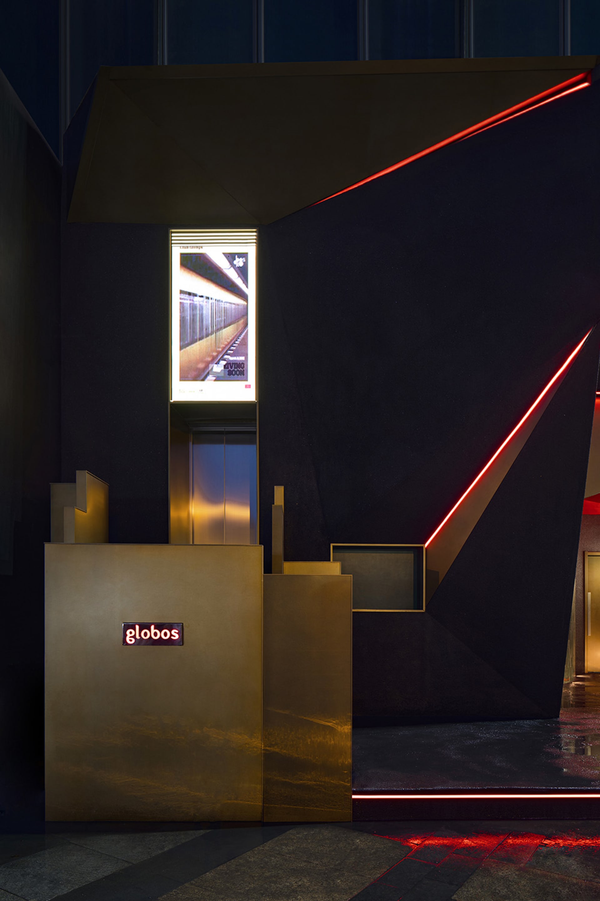 Modern hotel lobby with black and gold decor, two elevators, and a sophisticated atmosphere