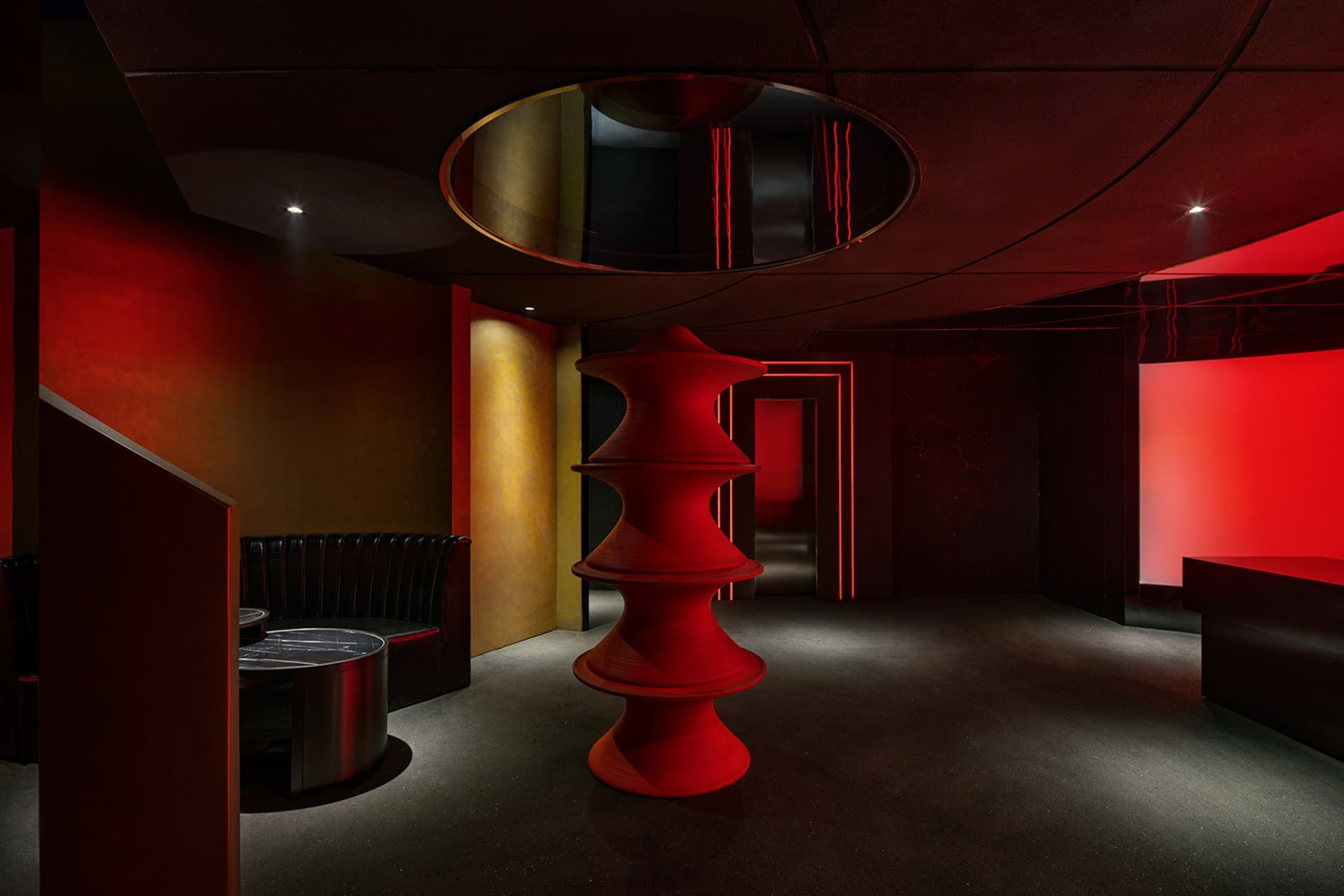 A darkened room with a red spiral staircase, two benches, and a mysterious atmosphere