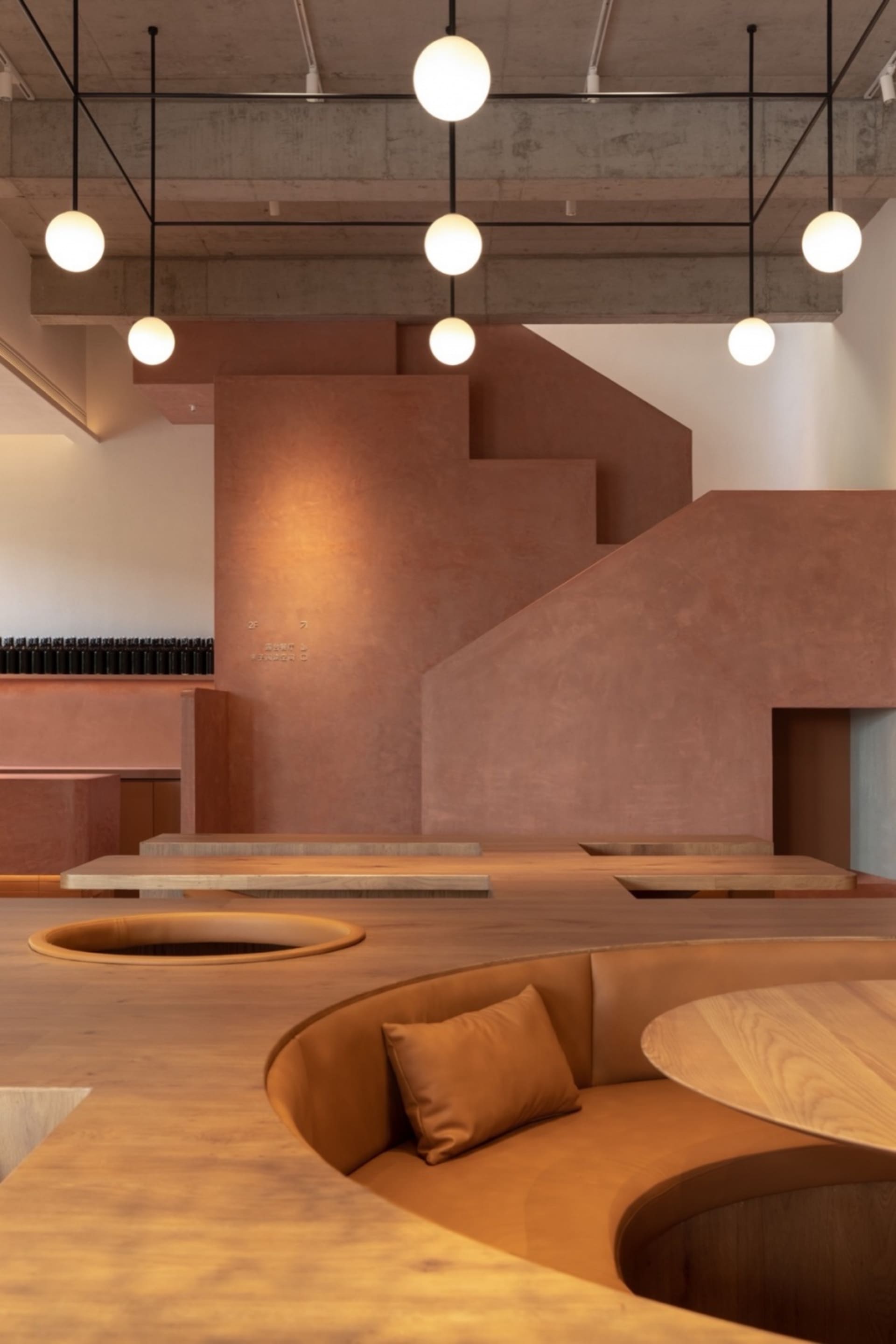 Warm and inviting cafe interior with wooden floors, concrete walls, and cozy lighting