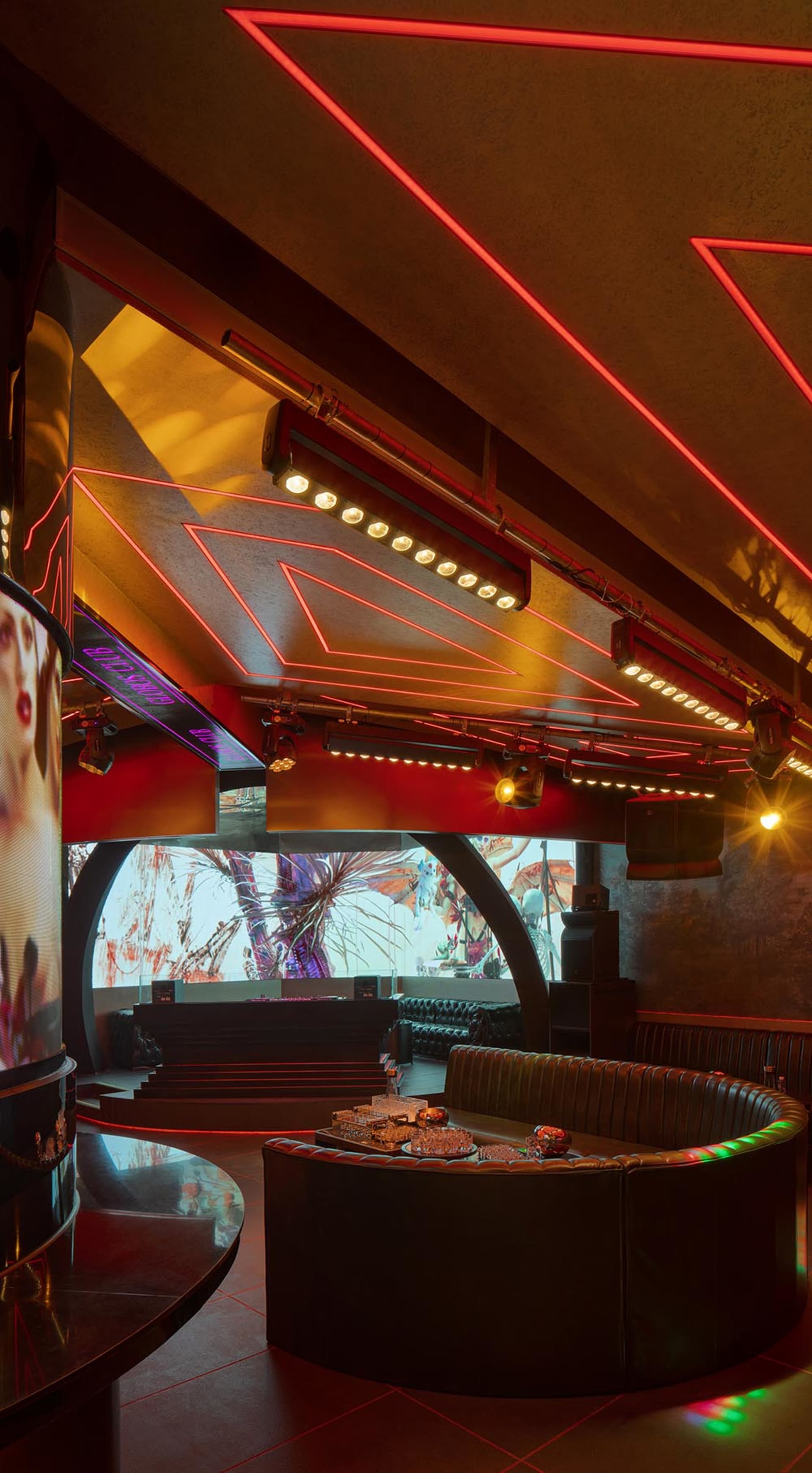 Modern club dining space with multiple tables, couches, and red accent walls, creating a warm and inviting atmosphere