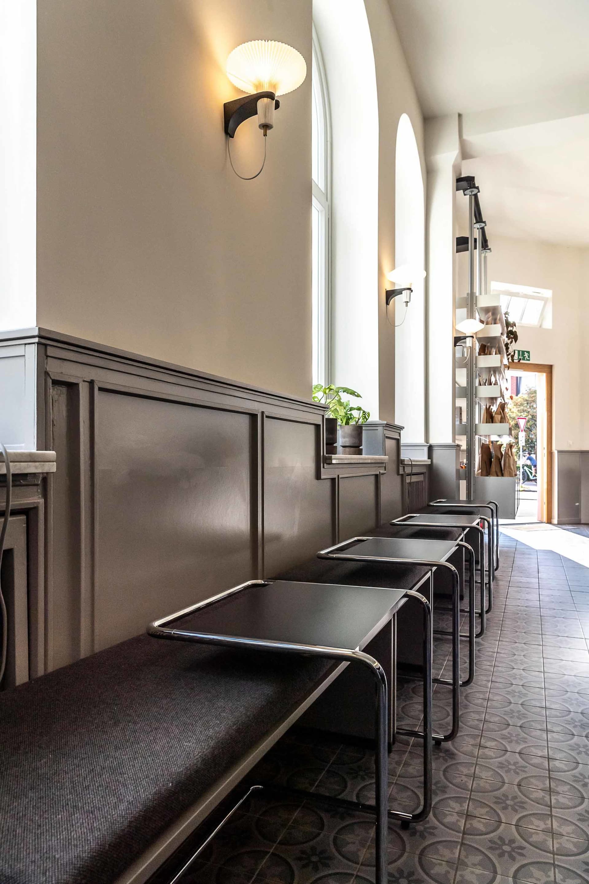 A cozy cafe with a long counter lined with black chairs, inviting customers to sit and enjoy their meals or drinks