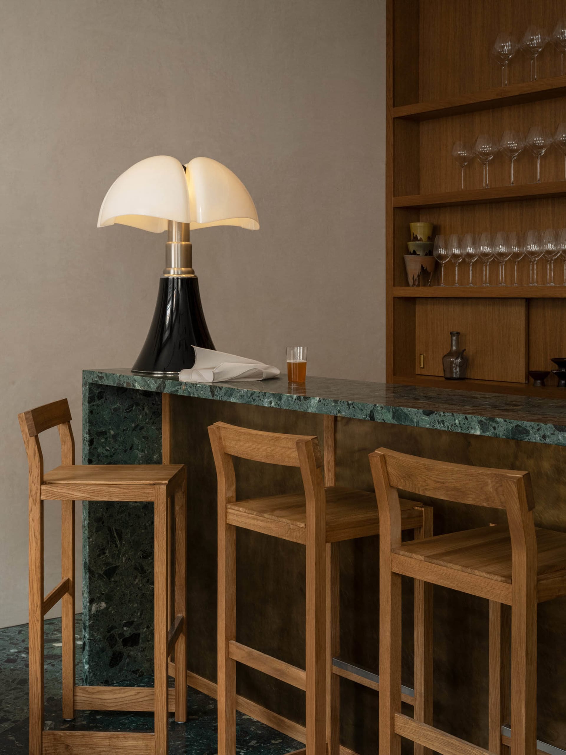 Inviting bar area with a marble countertop, wooden stools, and wine glasses, set in a stylish and sophisticated space
