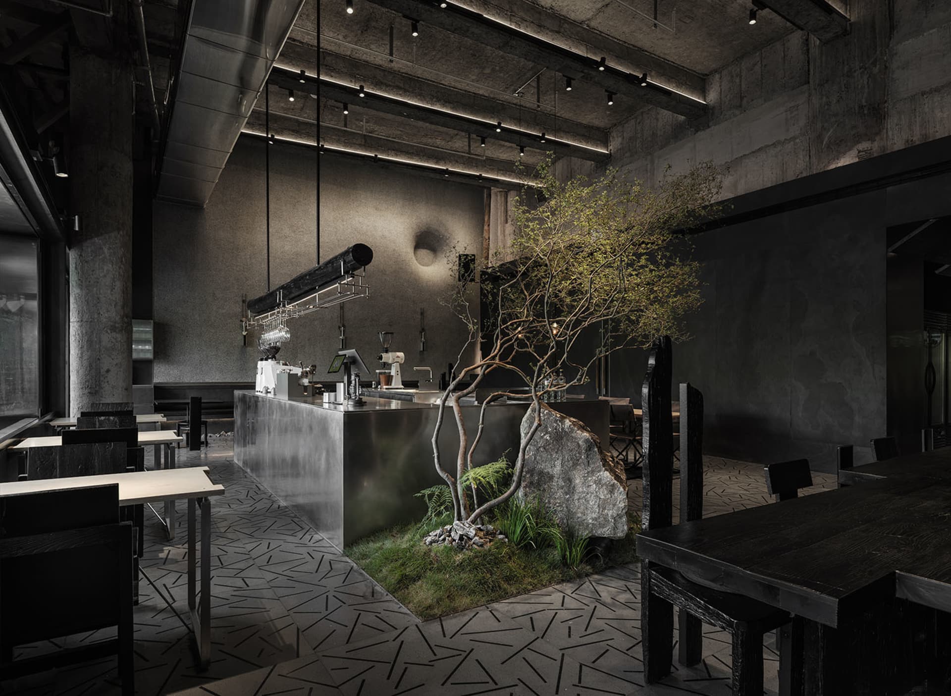 Modern cafe interior with concrete walls, wood elements, and a large potted plant, featuring several dining tables and chairs, and decorative vases