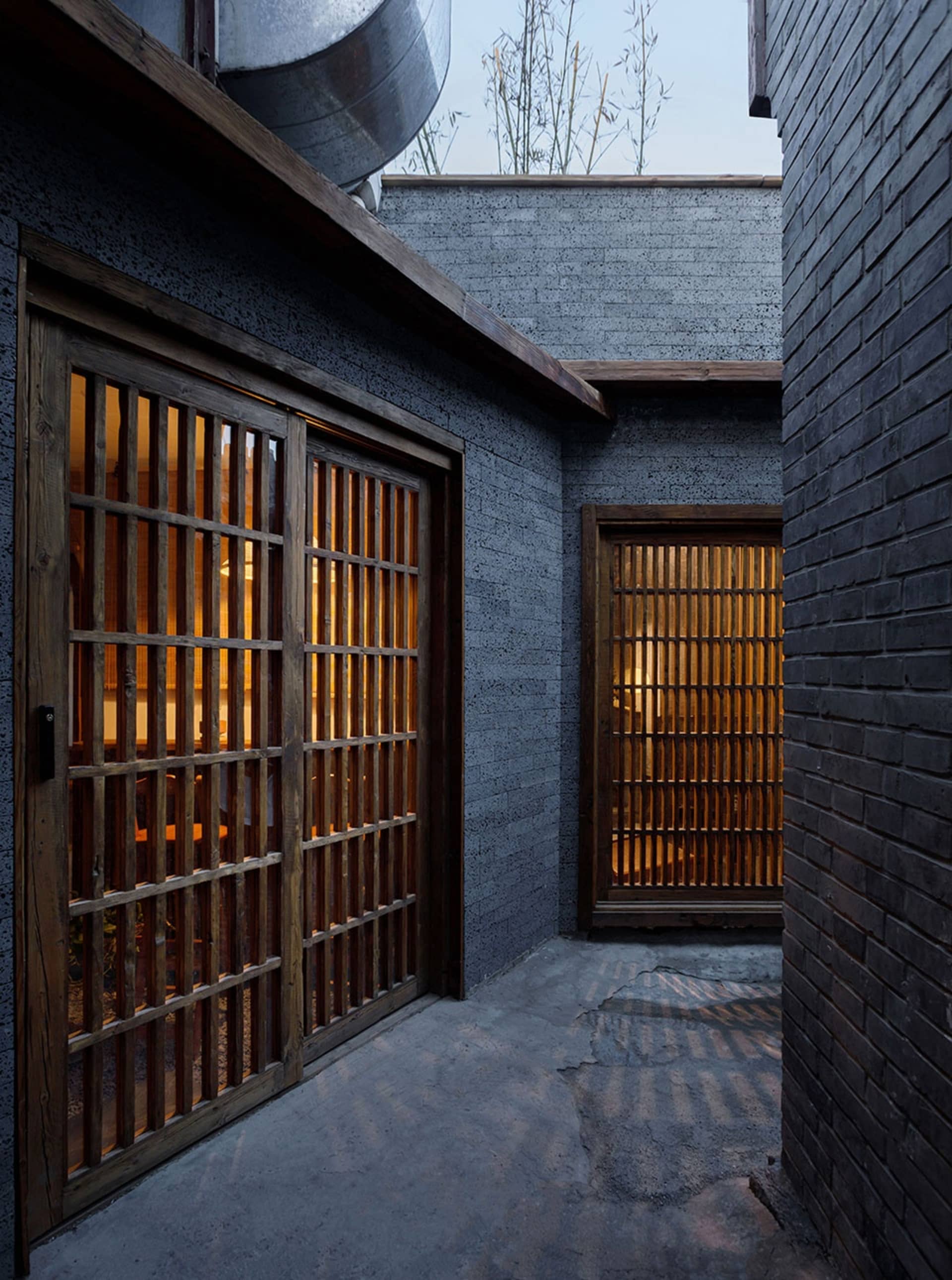 黑暗神秘的亞洲風格住宅，擁有黑磚外牆與有限自然光線