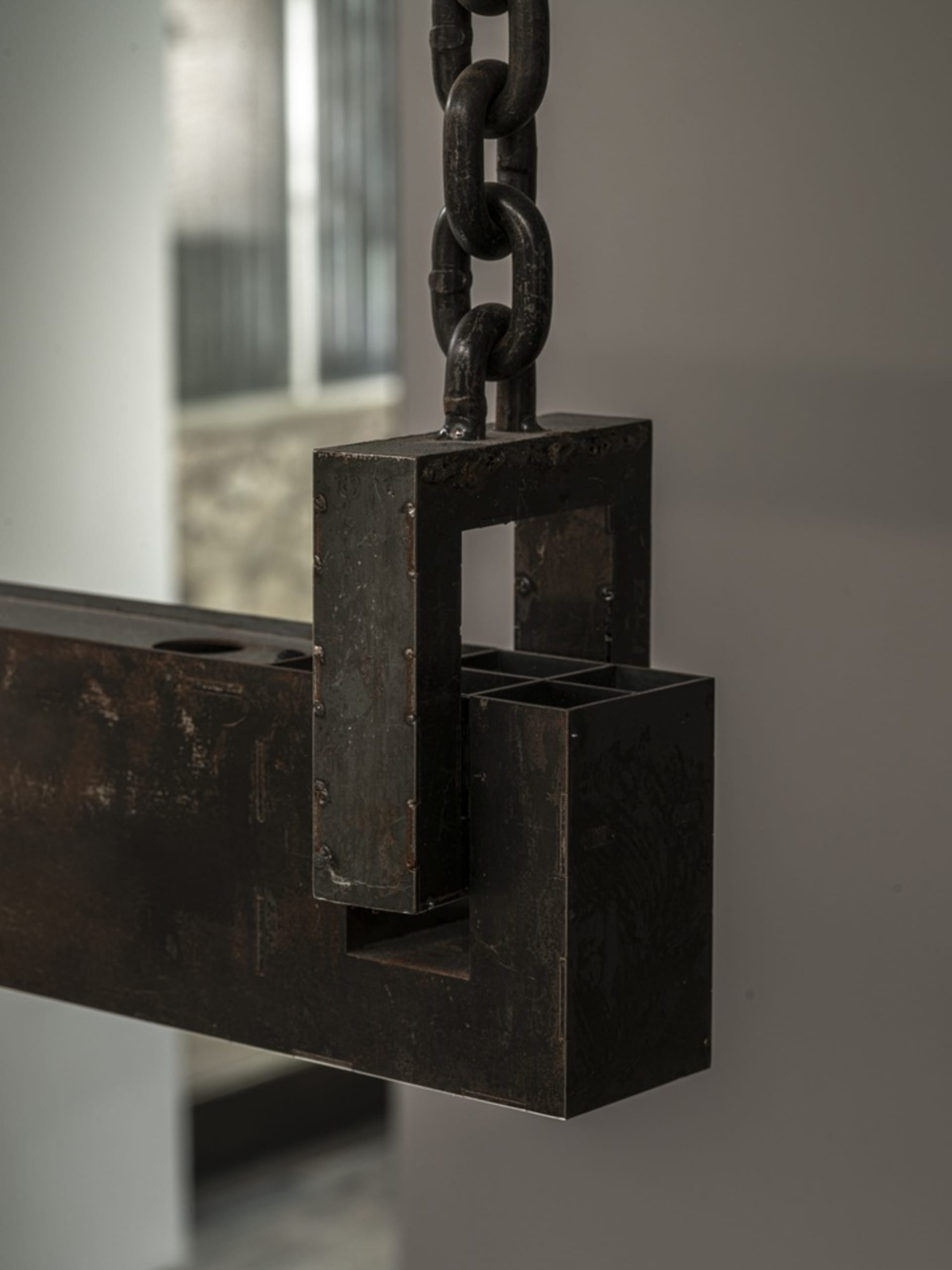 Exposed metal structure with a chain hanging from the ceiling, featuring a mix of industrial and antique elements