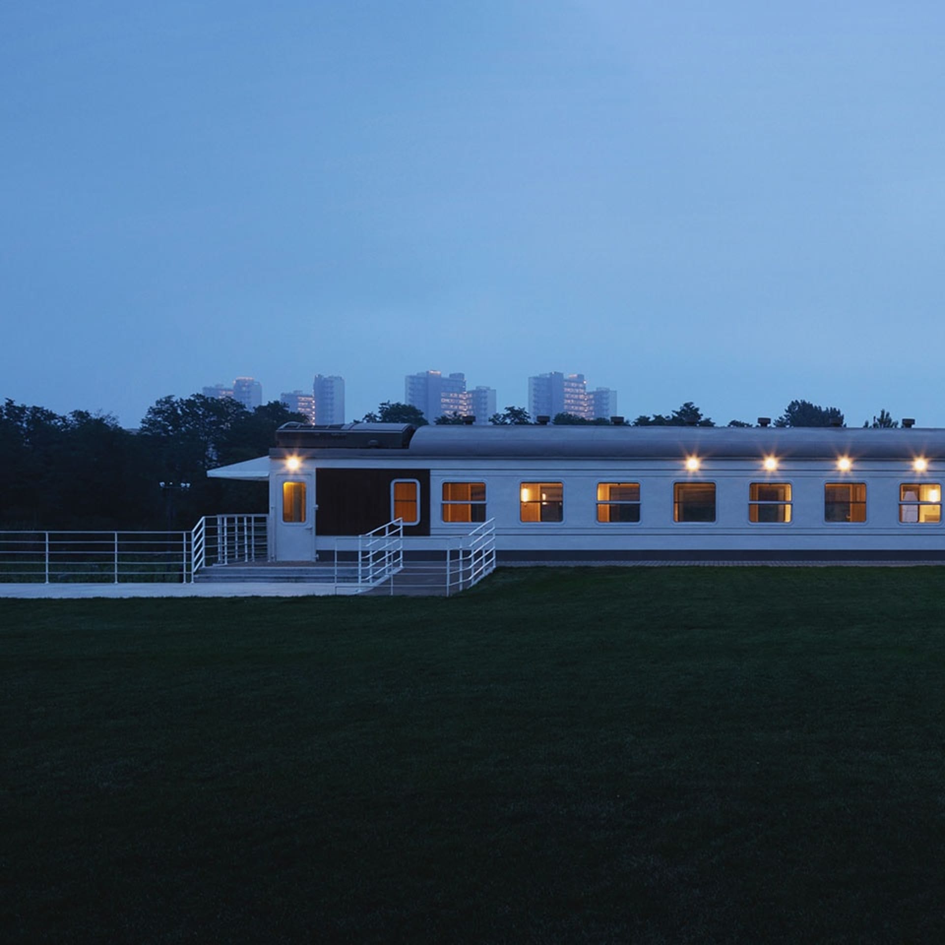 A modern building with a living area and dining area, lit by natural light and featuring clean lines and minimalistic elements