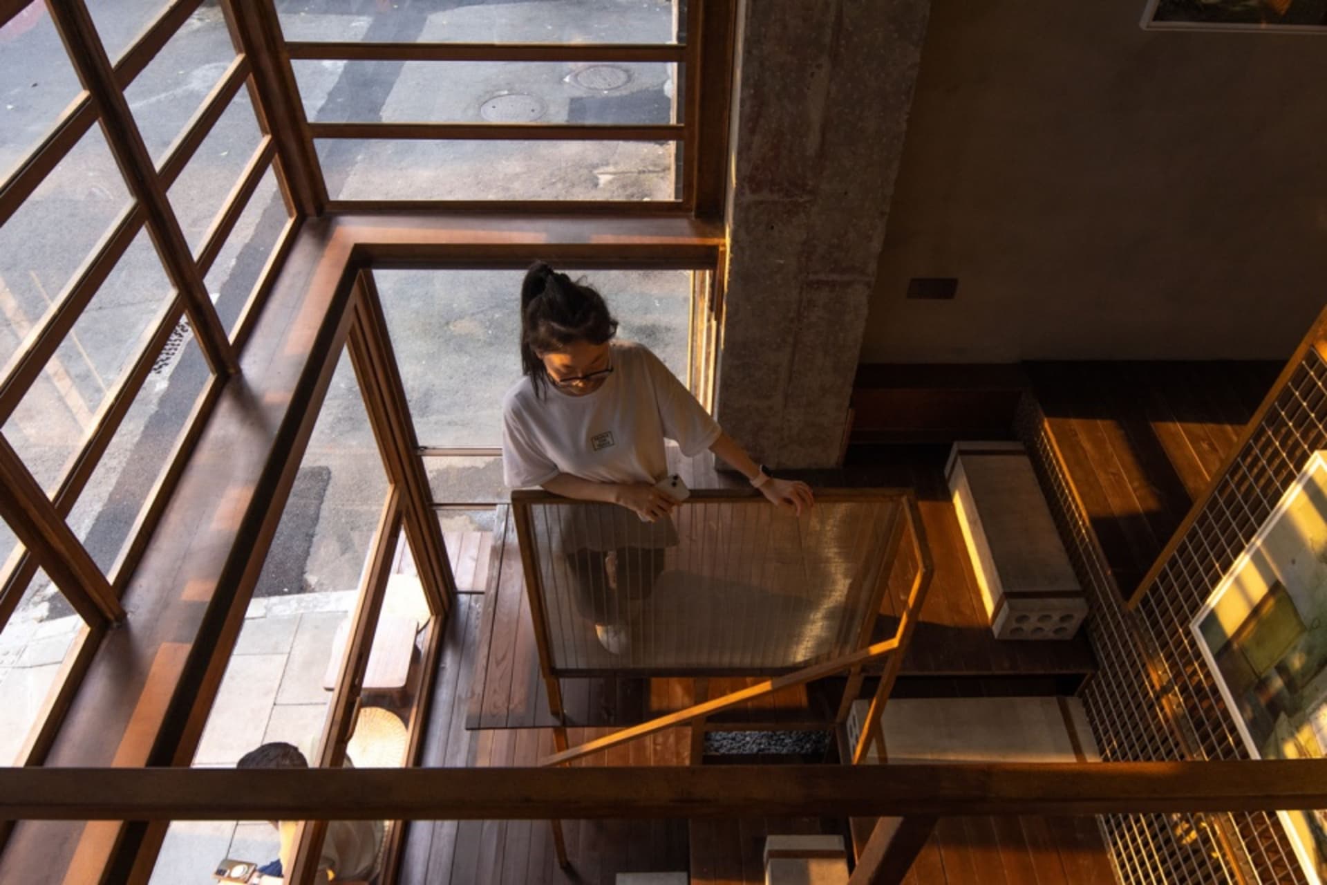 A well-lit interior space with a woman standing in front of a glass display case, possibly containing an art piece or artifact