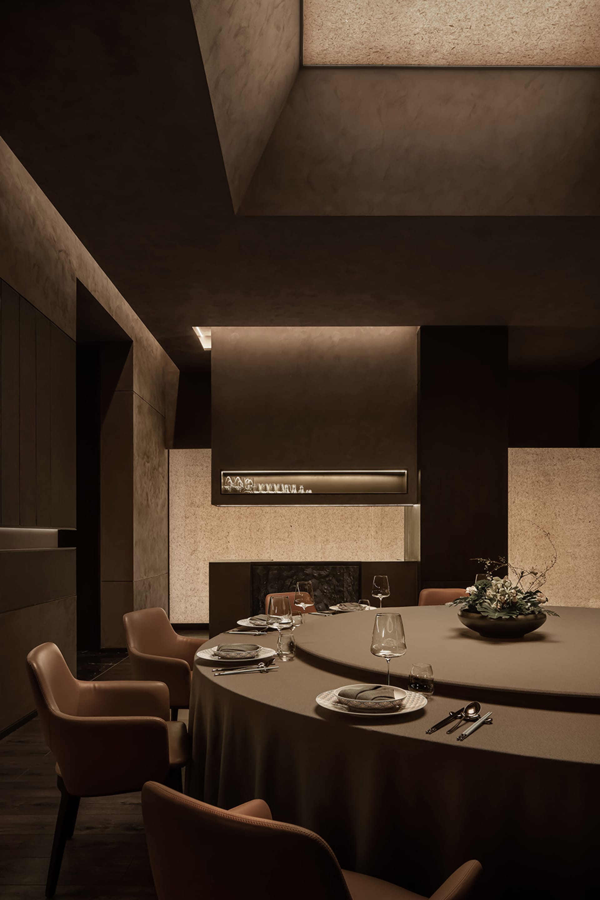 A modern dining area with a round table, dark wood elements, and warm brown and white tones, creating a cozy atmosphere