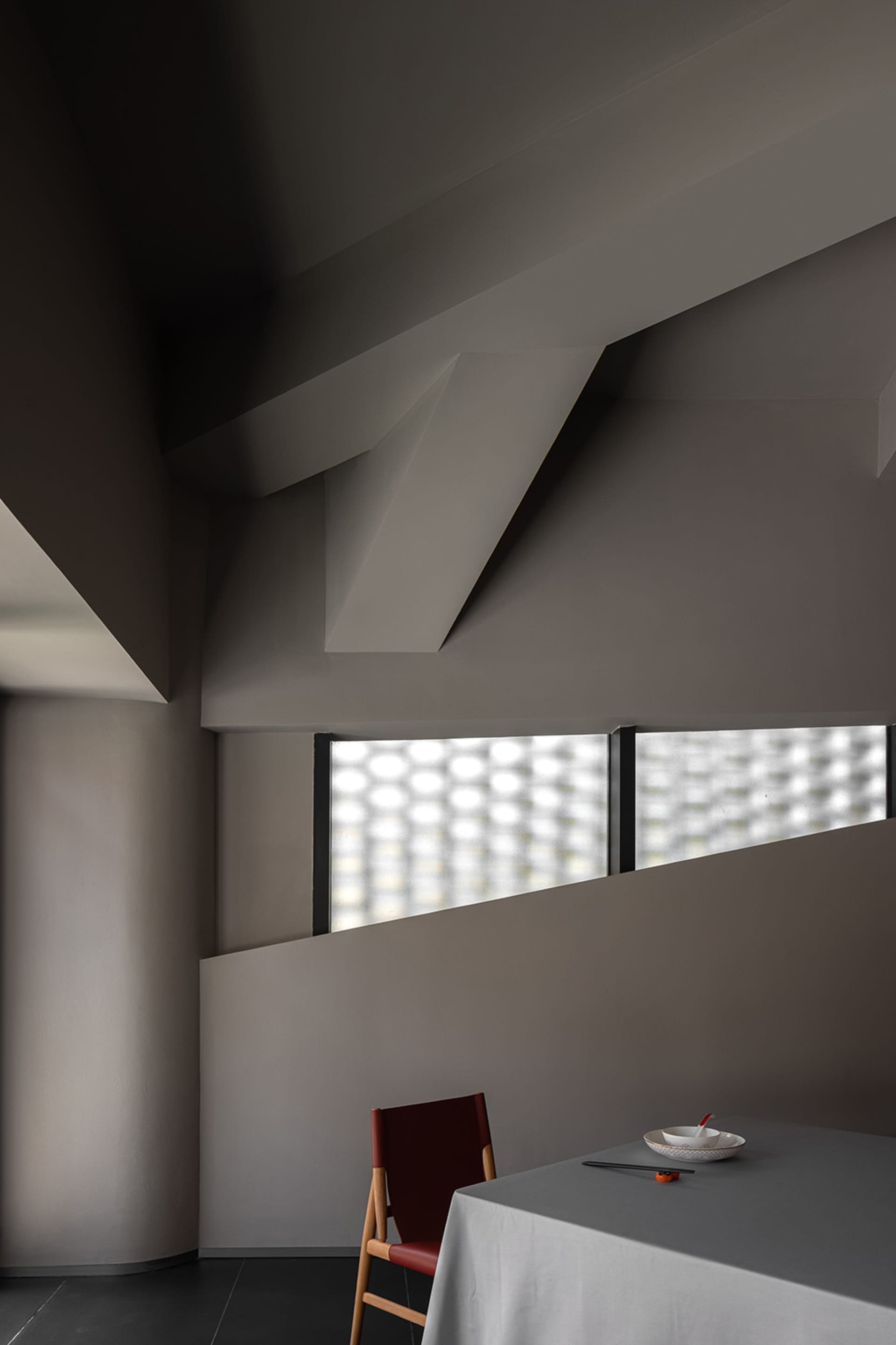 Interior view of a modern house with concrete walls, two windows, and a focus on design elements