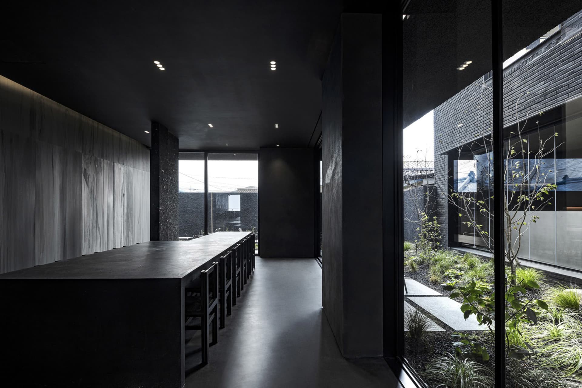 Empty restaurant interior with a black table surrounded by chairs, creating a dark and mysterious atmosphere