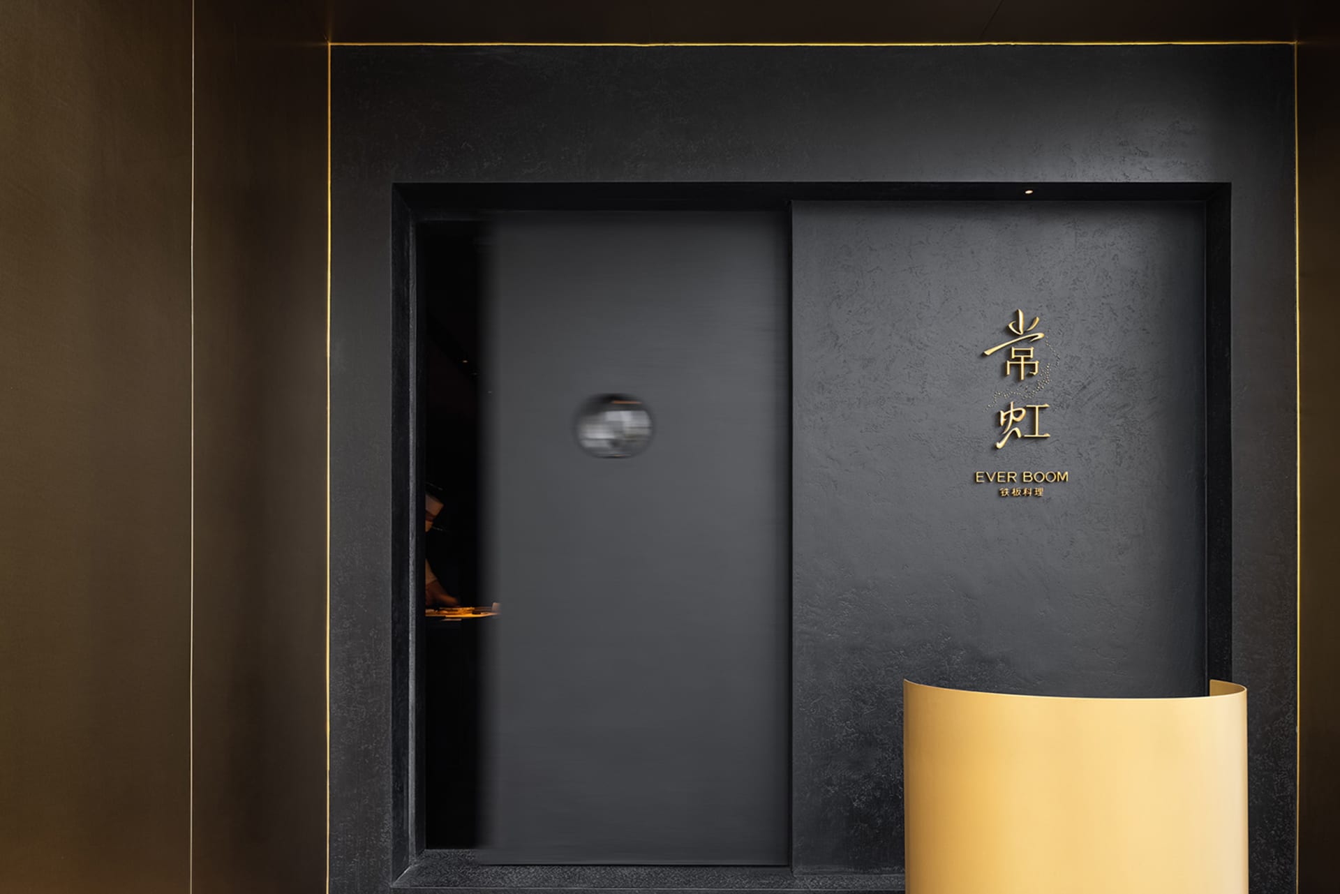 一扇黑色大門的暗色入口，前方站著兩人，充滿神秘氣息