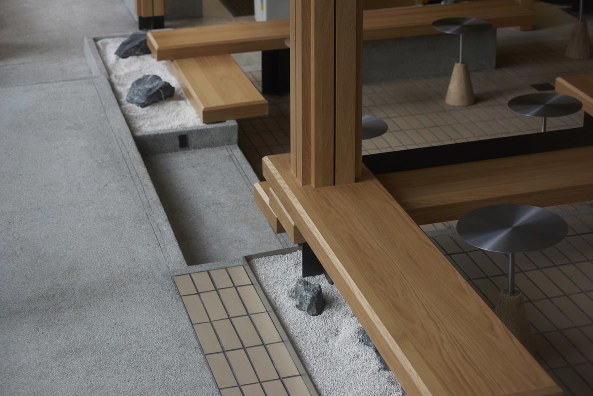 Cozy living space with wooden floors and walls, featuring benches with rocks and a warm atmosphere