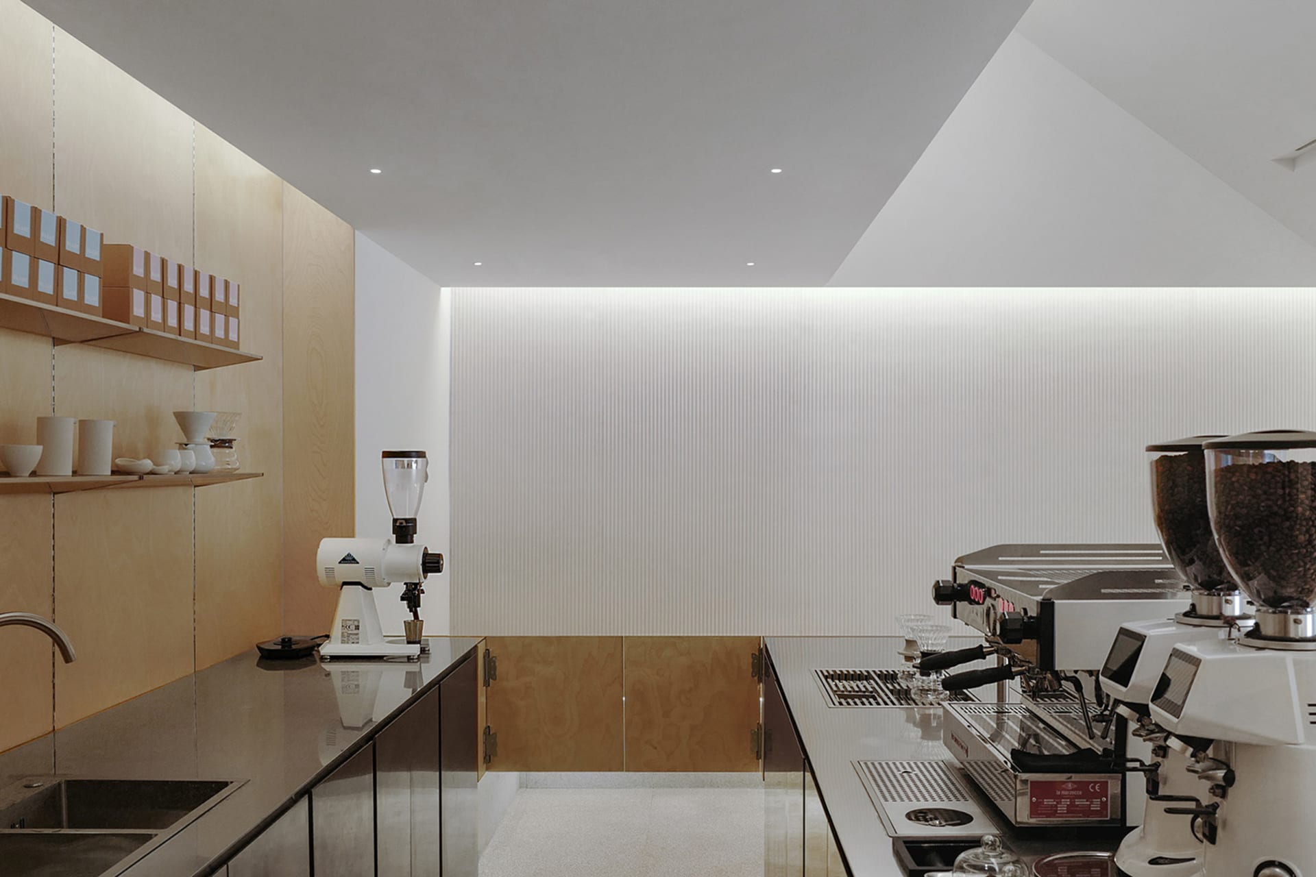 Modern kitchen with white walls, appliances, and bottles, featuring a clean and bright appearance