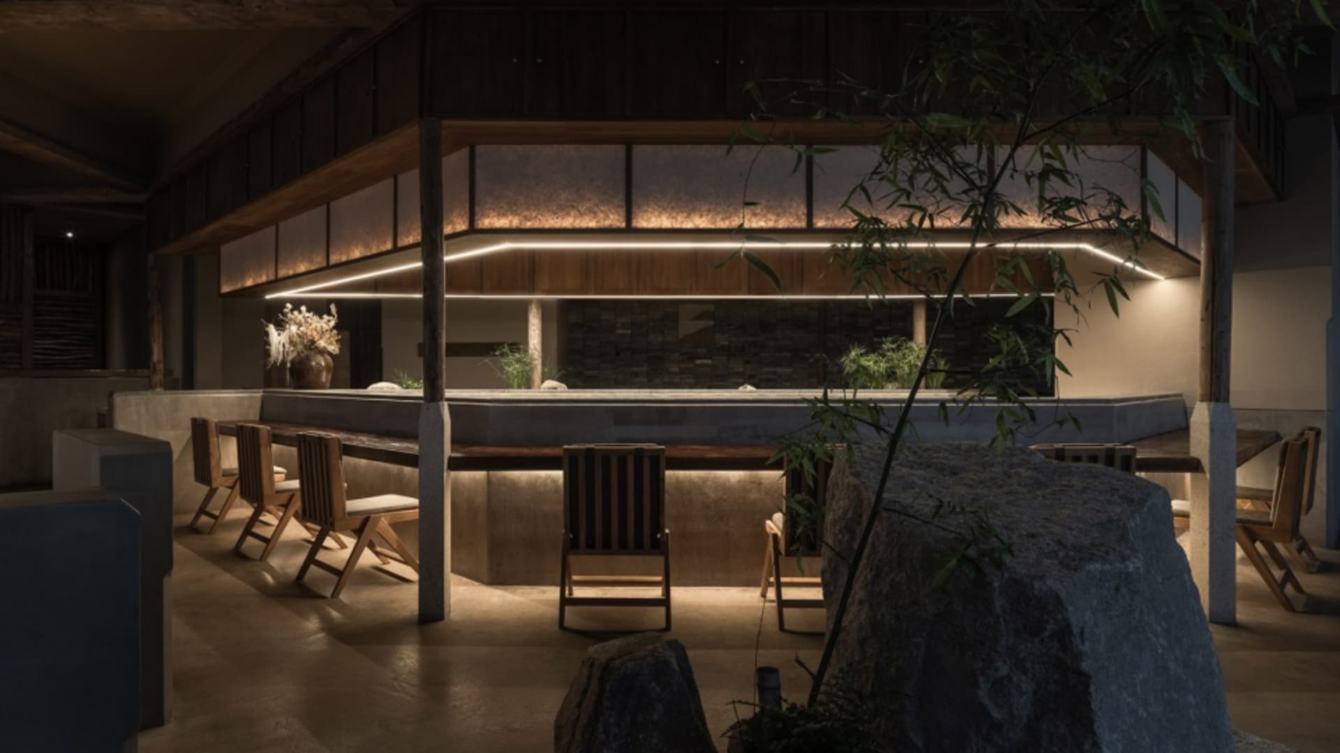 溫暖舒適的餐廳內部，搭配木質元素、石牆、椅子與盆栽