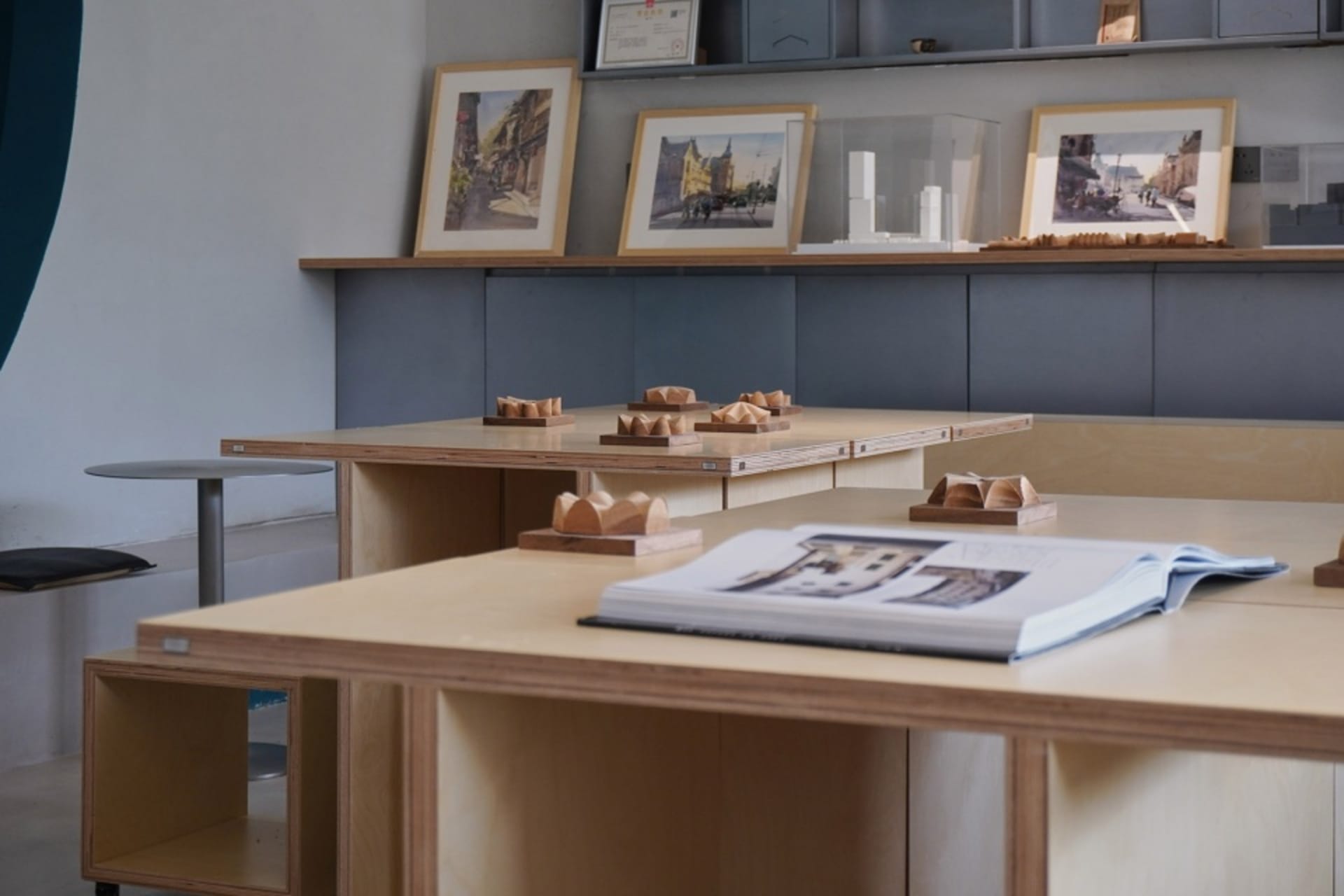 A well-organized office space with a wooden desk, book, and framed pictures on the wall, providing a comfortable work environment