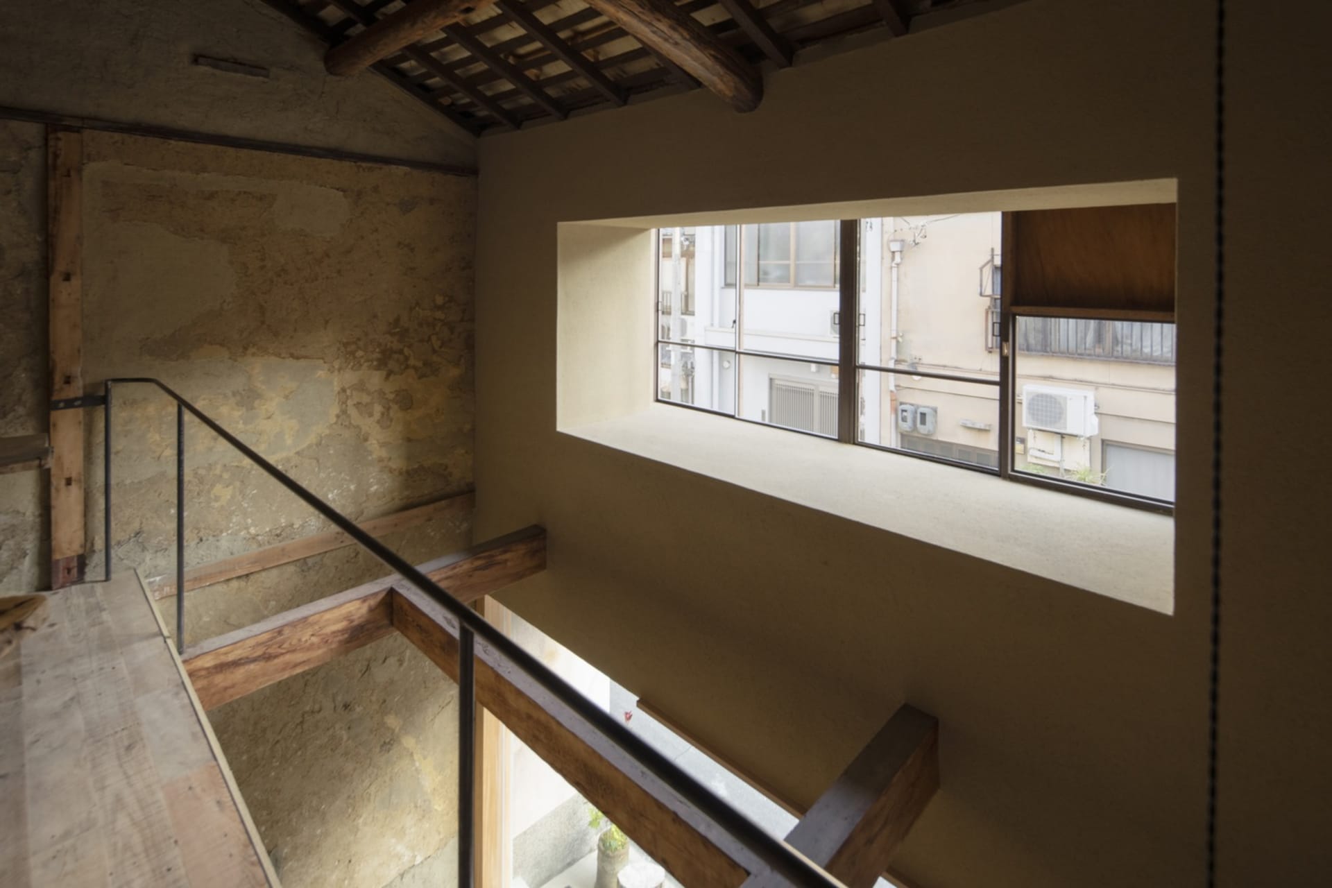 A historic building with a wooden staircase, natural light, and old architecture