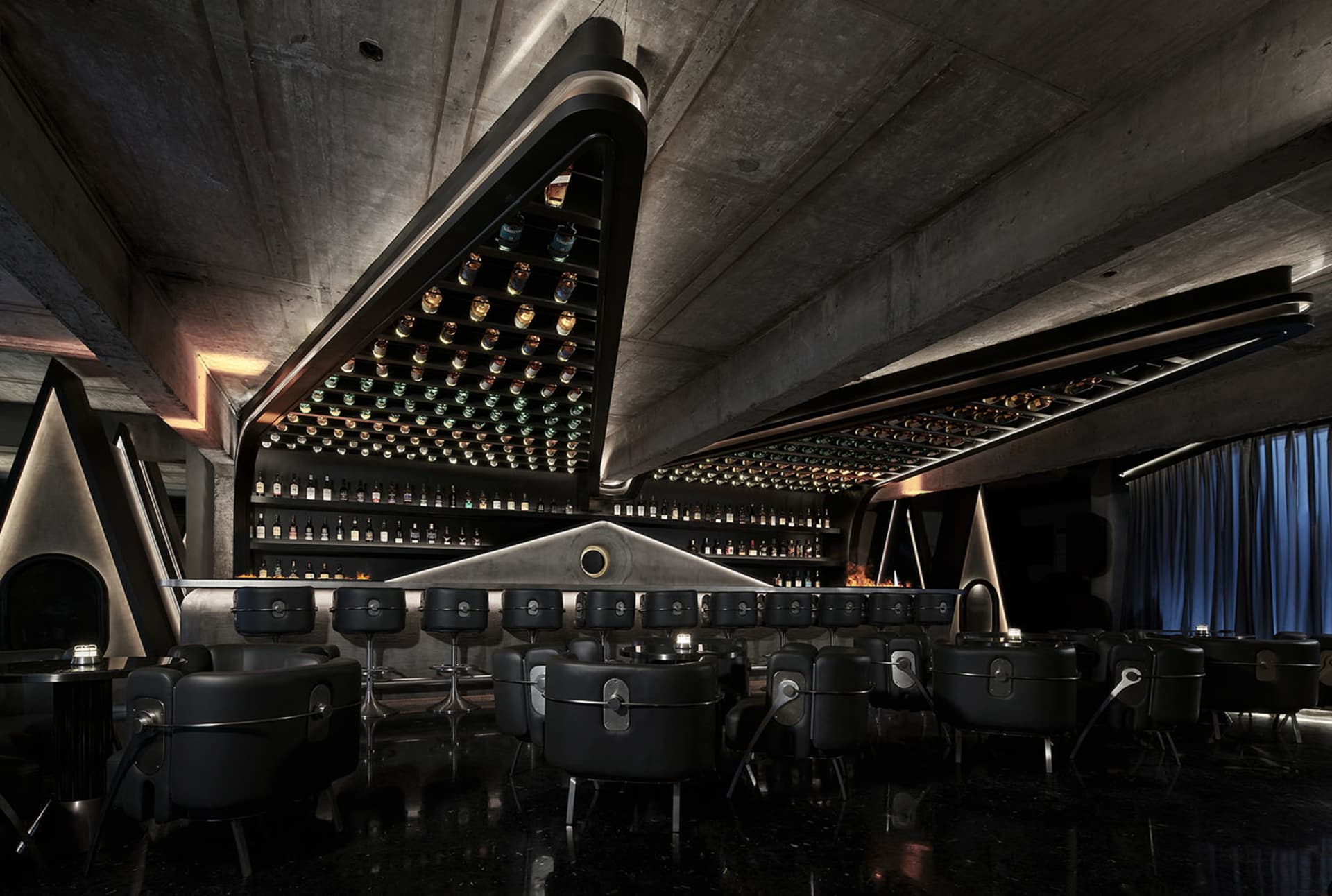 Elegant bar area with wine bottles on display, wooden chairs, and a sophisticated atmosphere