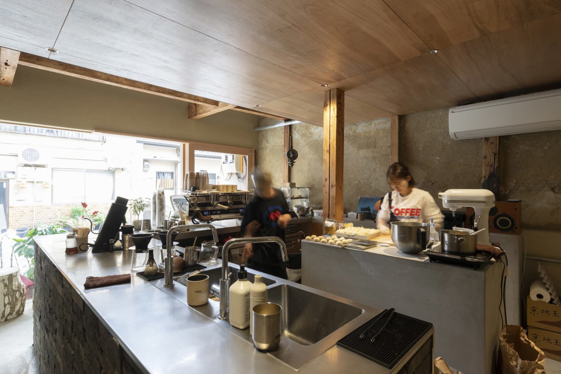 Busy commercial kitchen with a refrigerator, countertops, and various objects and appliances