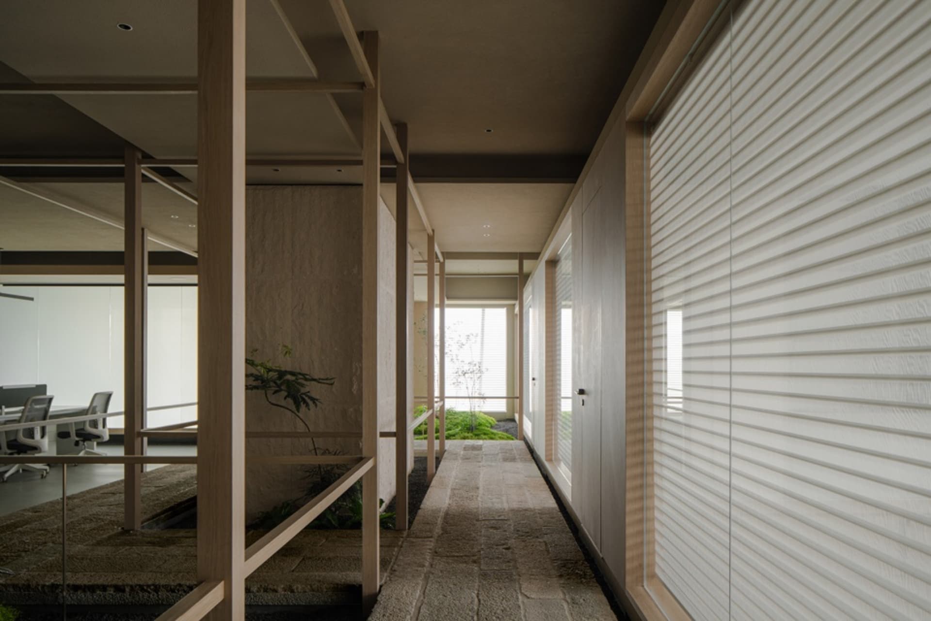 Warm and inviting living space with wooden walls and floor, potted plants, and decorative vases