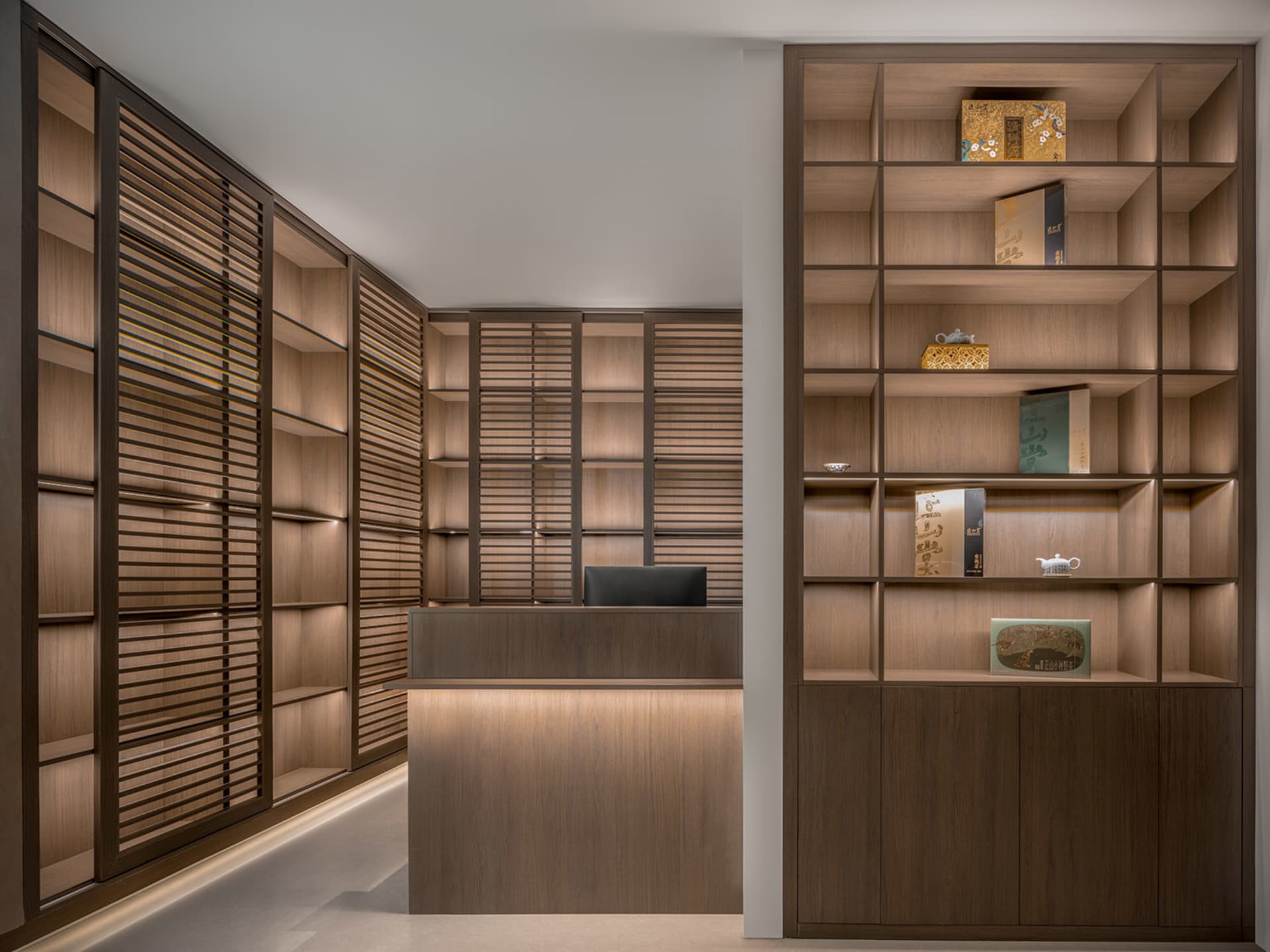 Warm office space with wooden floors and walls, featuring bookshelves, desks, and a laptop, creating a comfortable workspace for productivity and relaxation