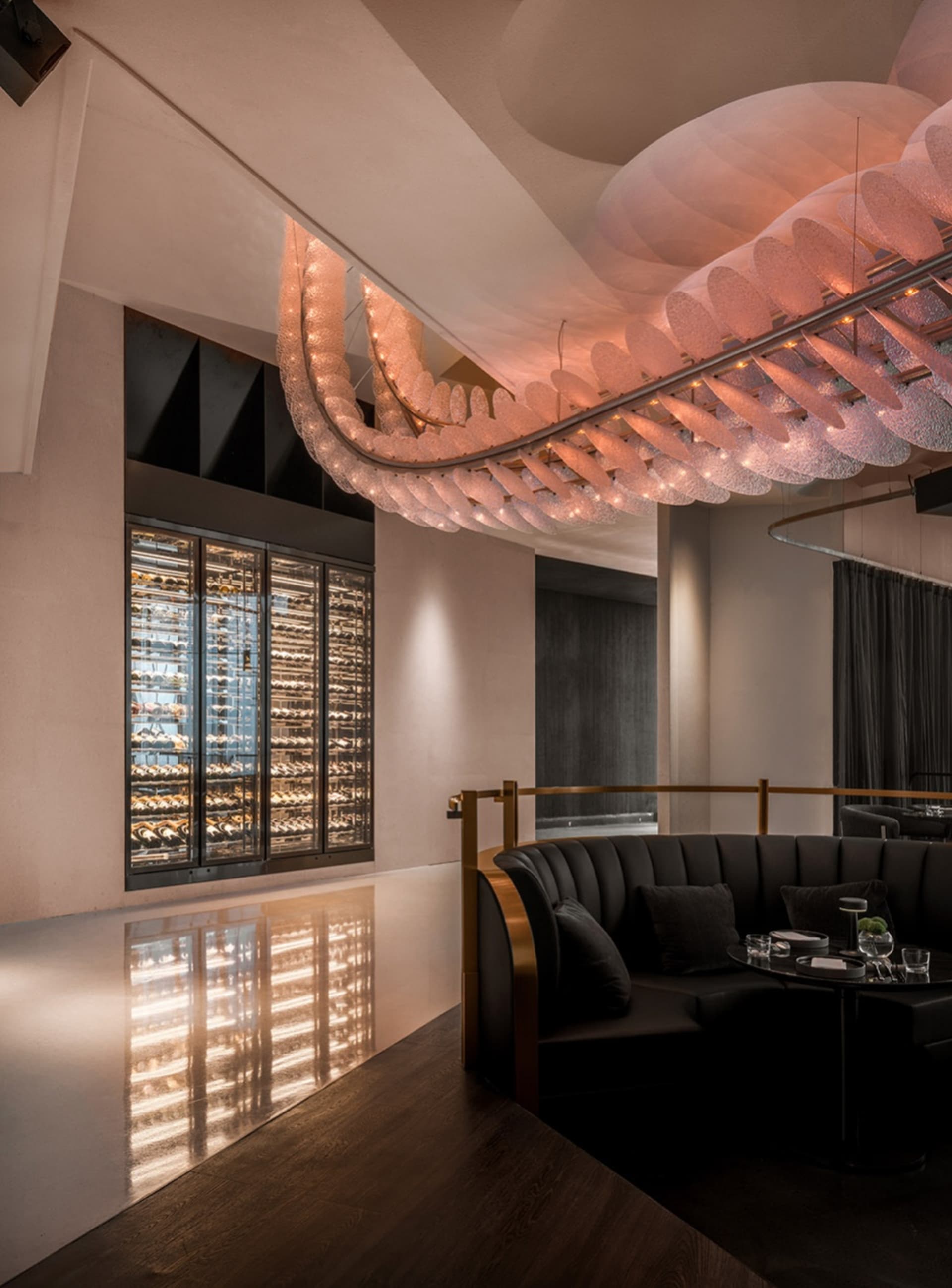 Sophisticated dining space with modern design, prominent hanging lights, and wine glasses on tables