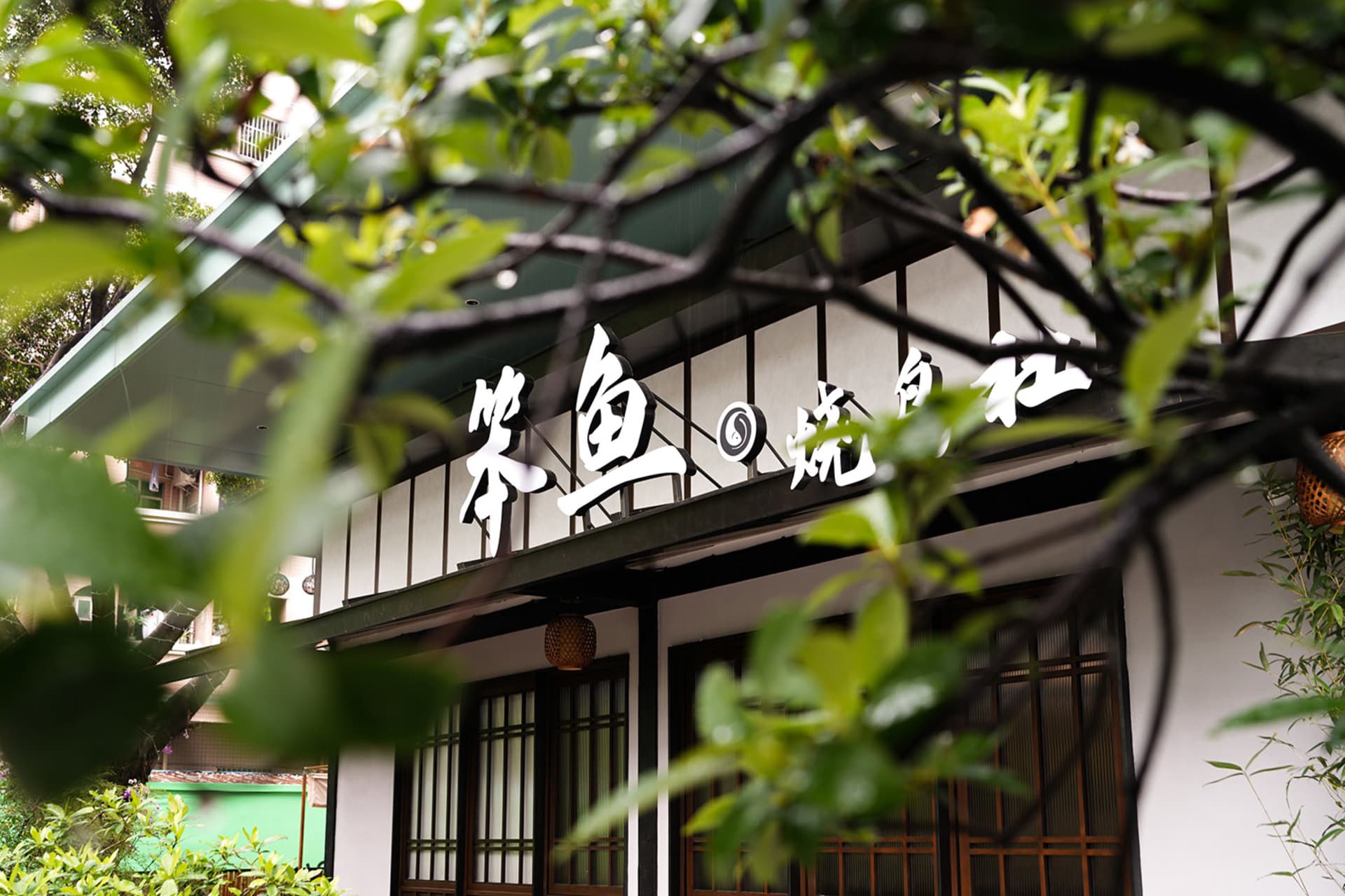 現代亞洲餐廳，白色外牆、黑色屋頂，以及戶外座椅區