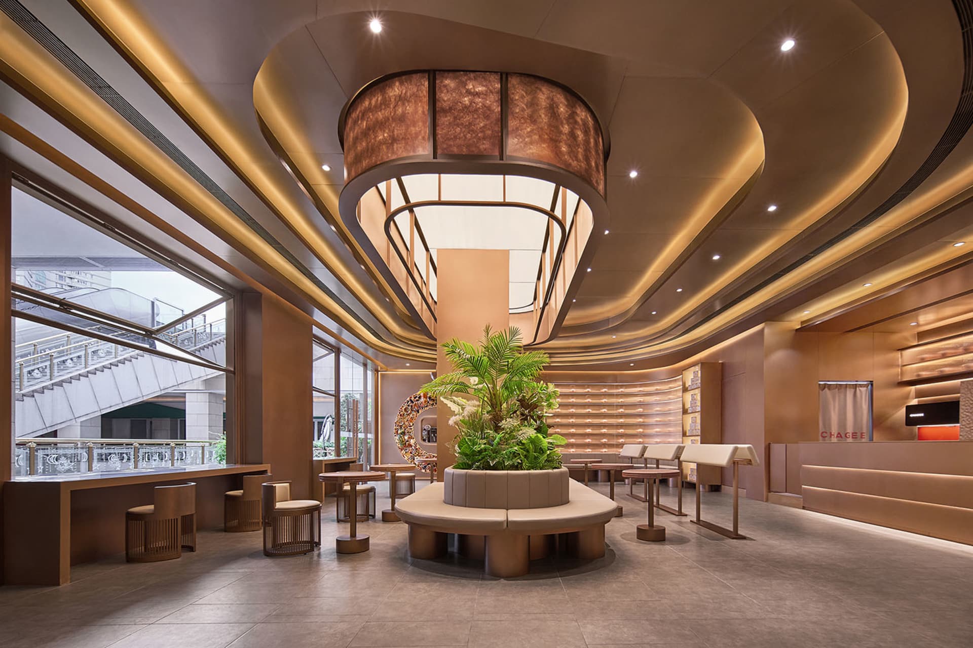 A large open retail space with a high ceiling, potted plants, and chairs for customers to sit and relax