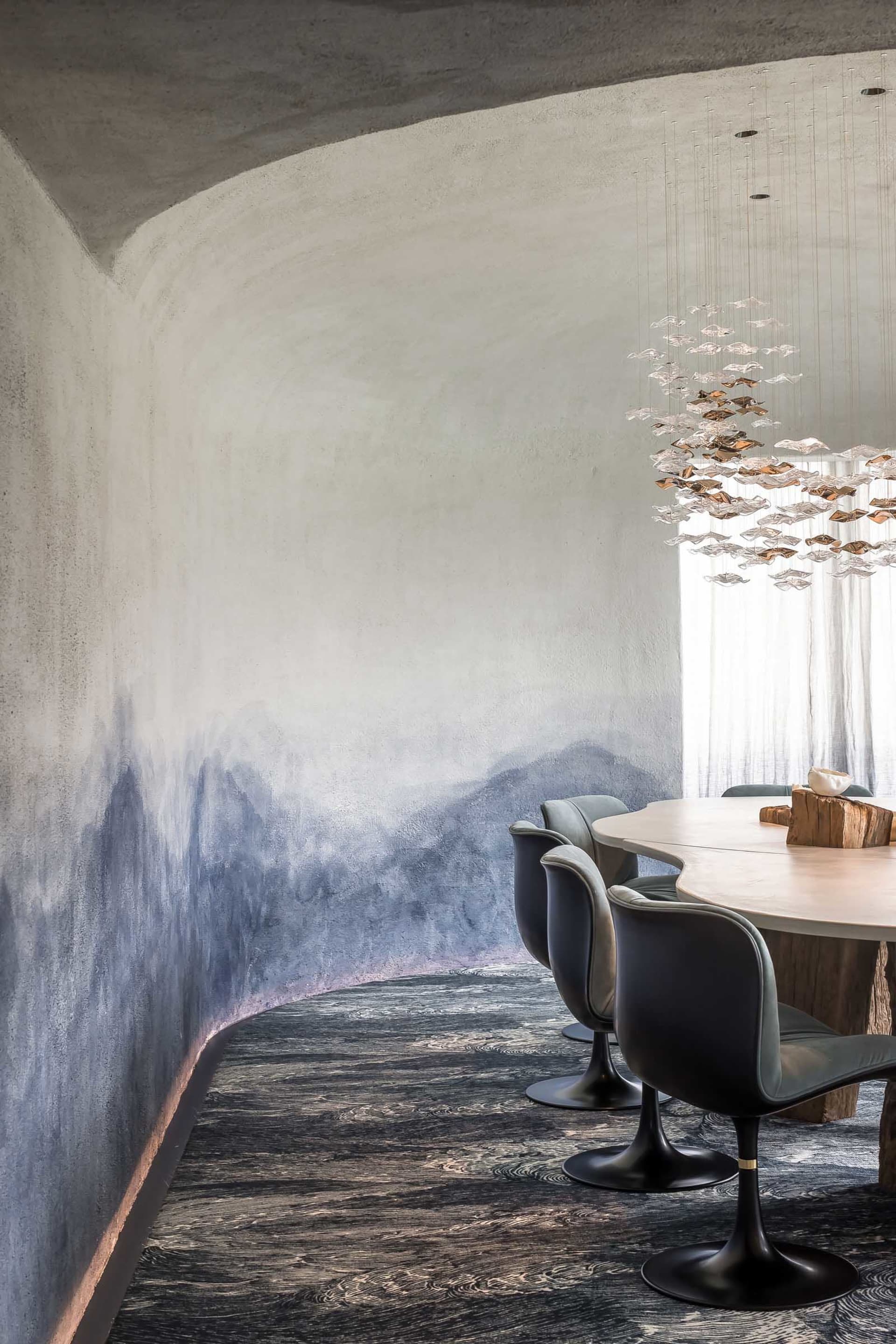 Dining area with a round wooden table surrounded by four leather chairs in a modern and stylish interior design