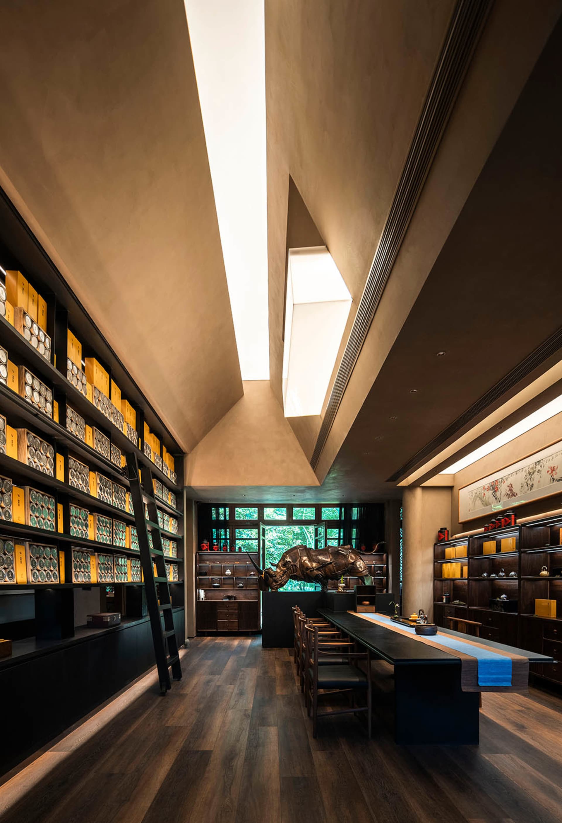 Modern dining area with wooden floors, a table, chairs, and books, creating a cozy atmosphere