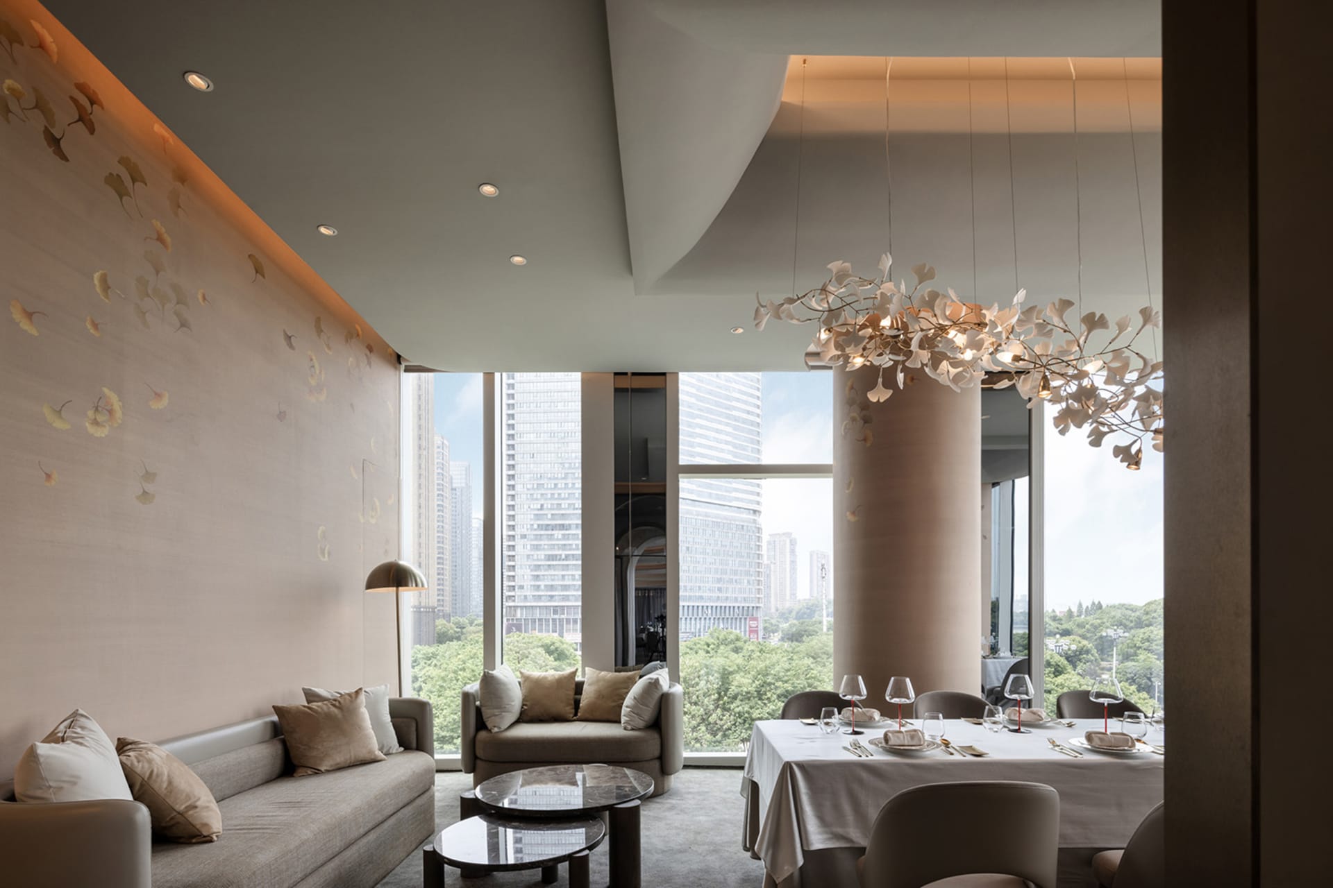 Elegant living space with a city view, two couches, a dining table, and decorative elements