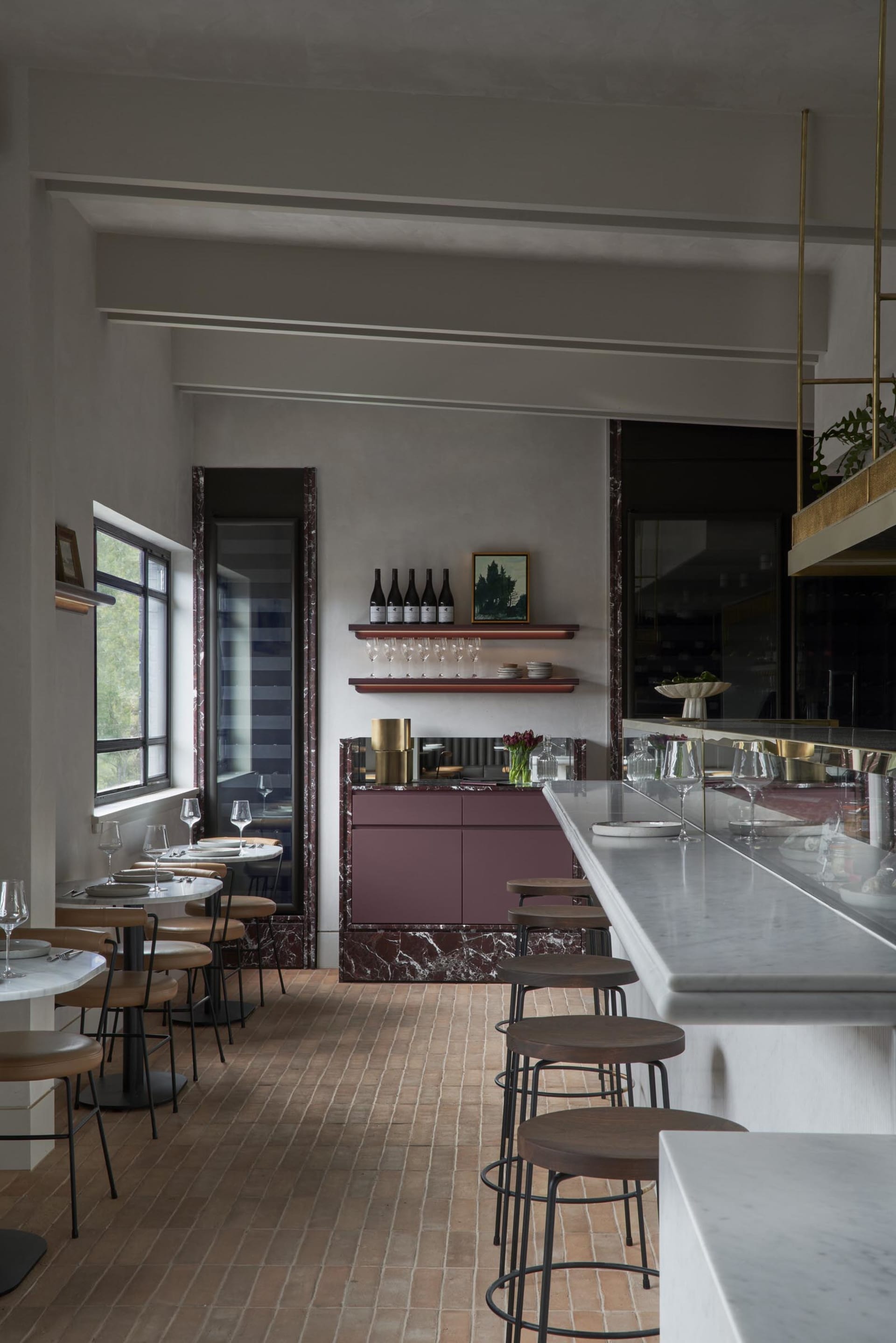 elegant restaurant interior with a large marble bar, chairs, and wine glasses