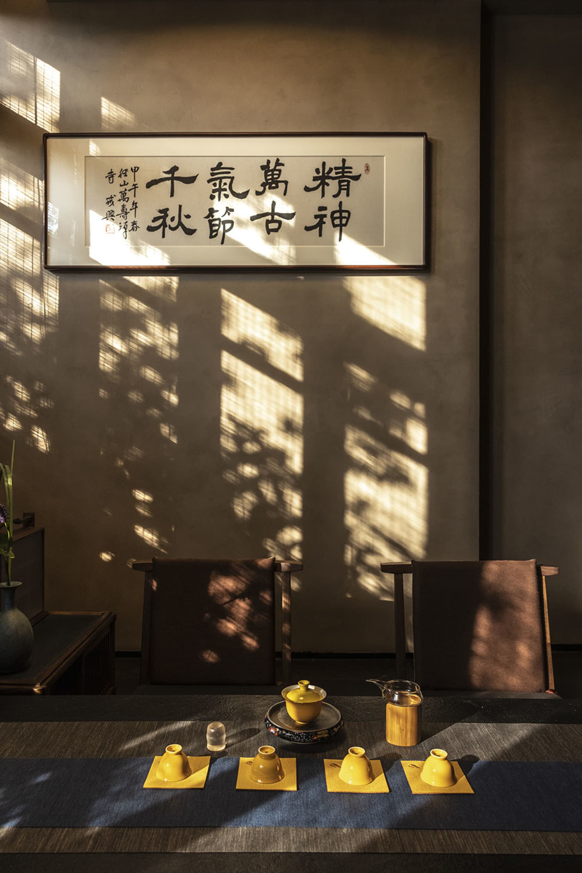 Dimly lit room with two chairs and a table, featuring Asian-inspired design elements and a cozy atmosphere