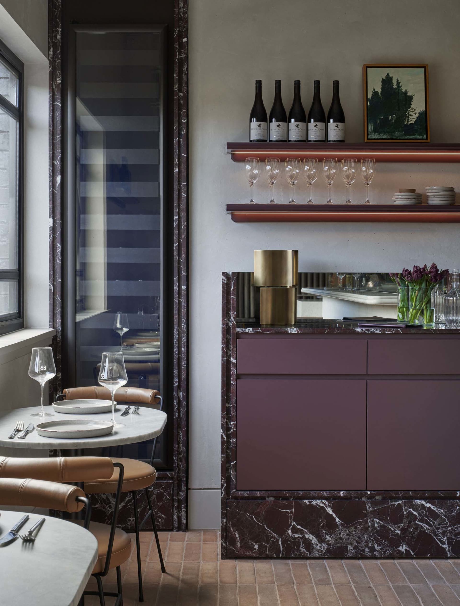 dining area with a marble table, chairs, wine glasses, cups, and bowls in a sophisticated restaurant setting