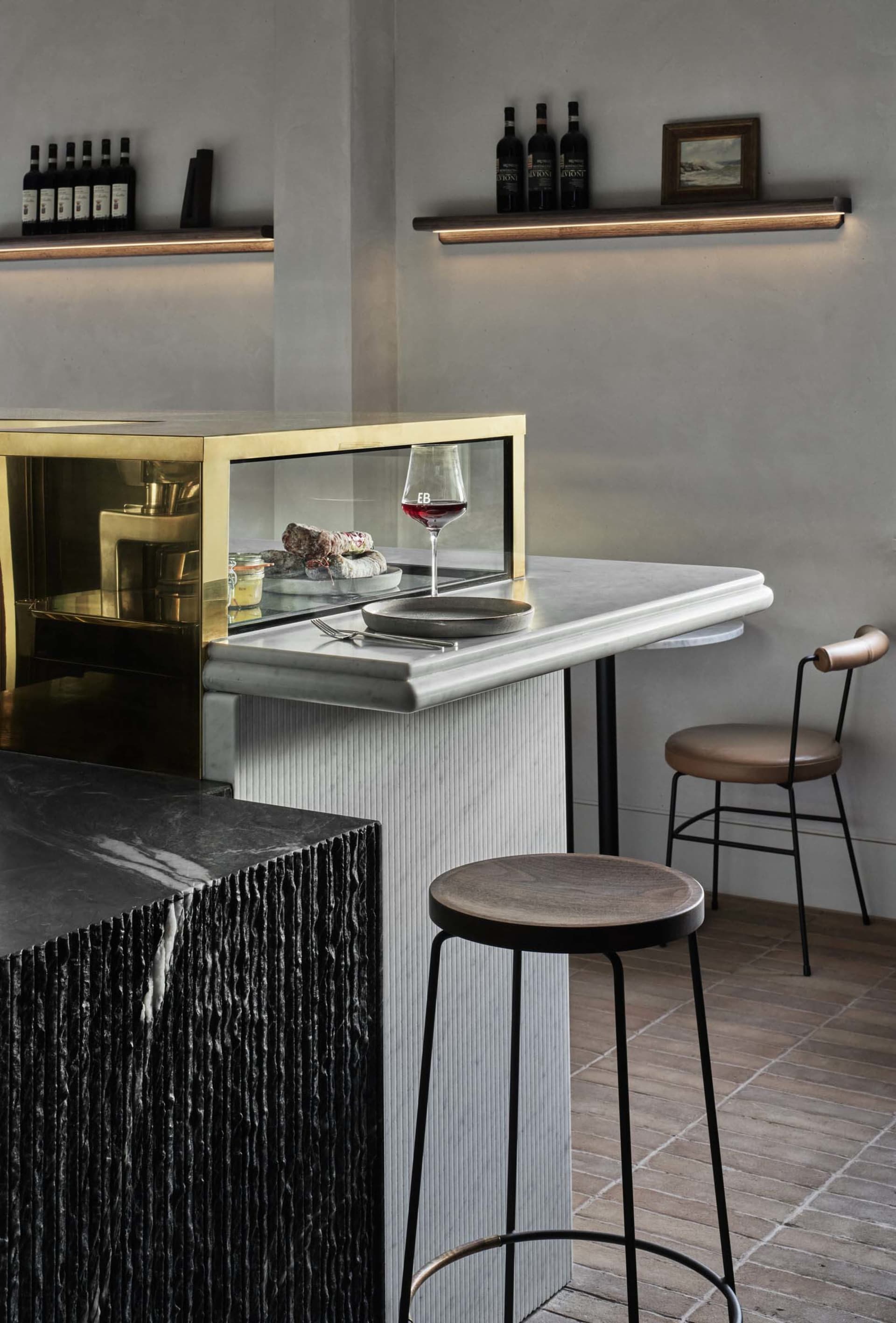 Elegant wine bar with a marble countertop, two chairs, and a wine glass, set in a sophisticated atmosphere with warm lighting