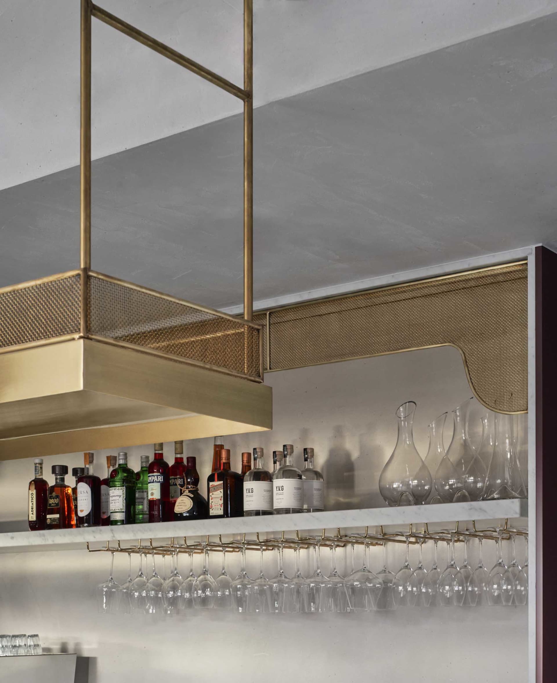 A sophisticated wine bar with wine glasses and bottles arranged on a countertop, creating a luxurious and inviting atmosphere for socializing and enjoying drinks