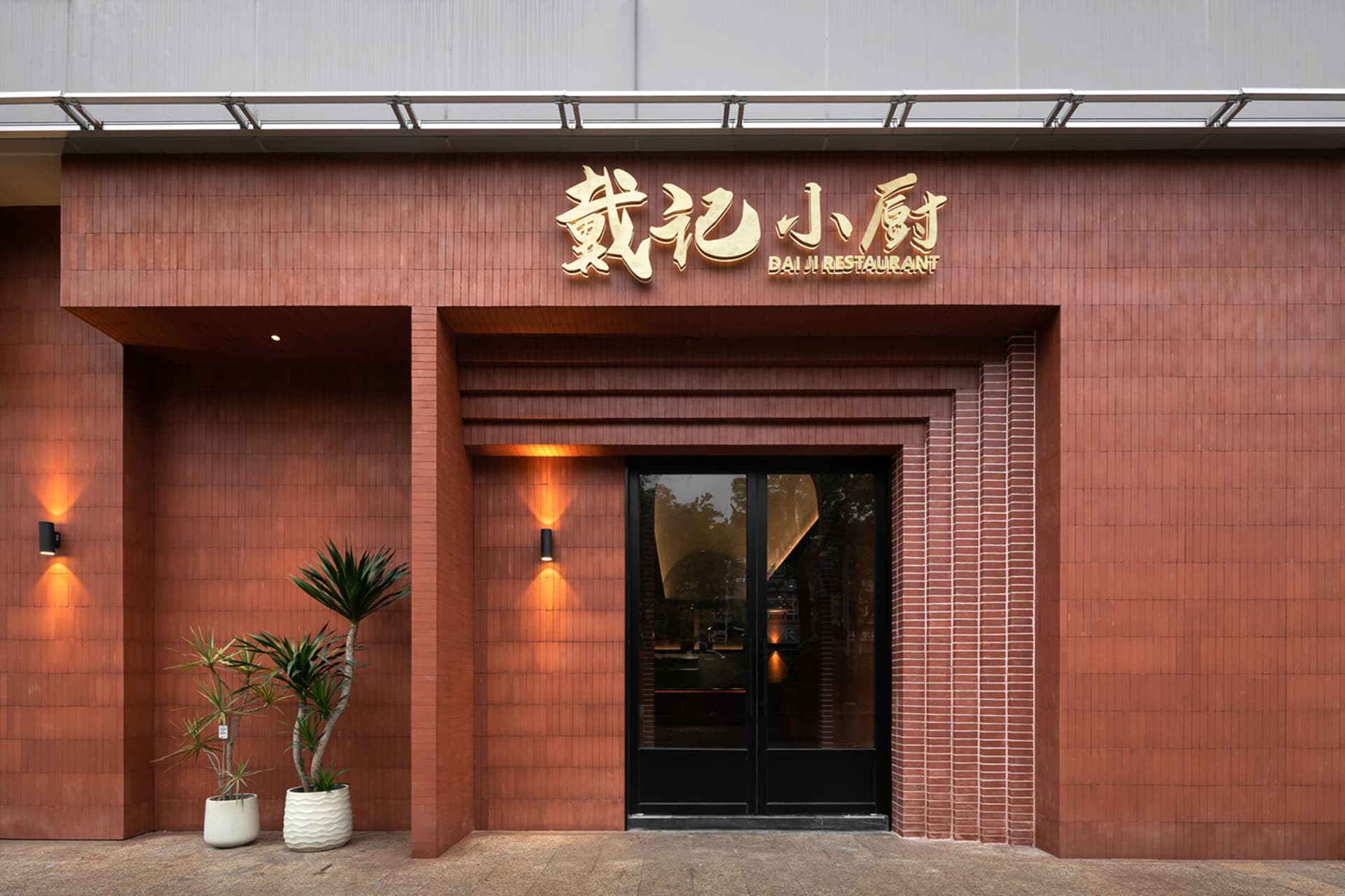 Warm and inviting Asian restaurant with a red brick exterior, black door, and interior dining area with a table and chairs