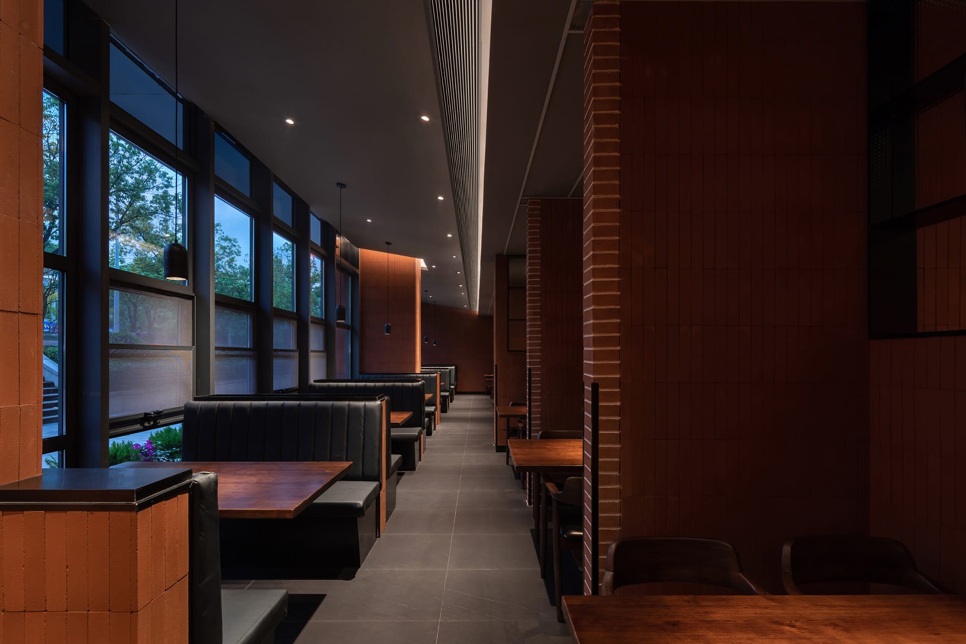 溫暖親切的餐廳內部，配有木質地板、磚牆，以及多張餐桌椅