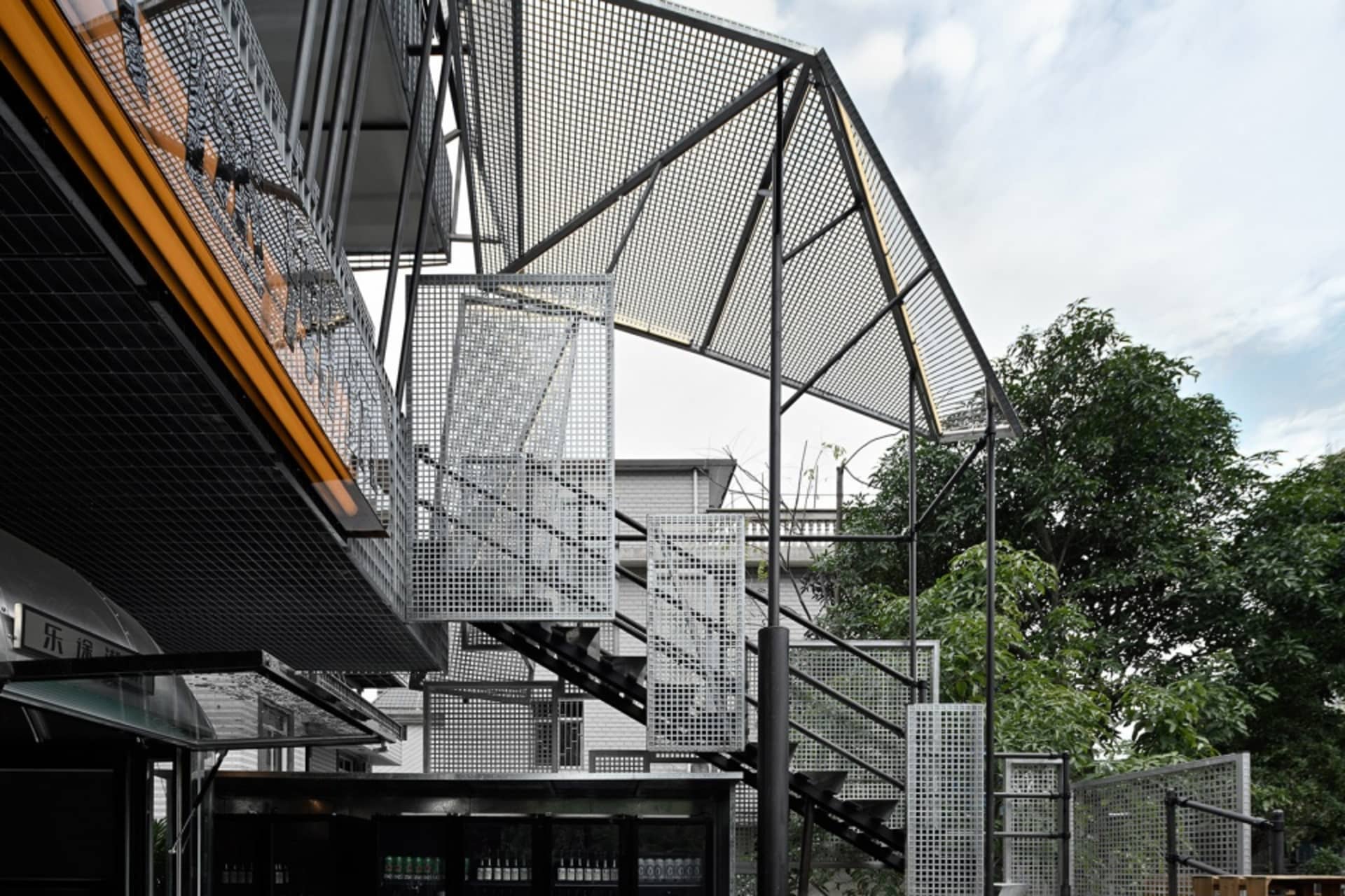 一座現代多層建築，具金屬結構與樓梯，展現建築風格與材質的融合
