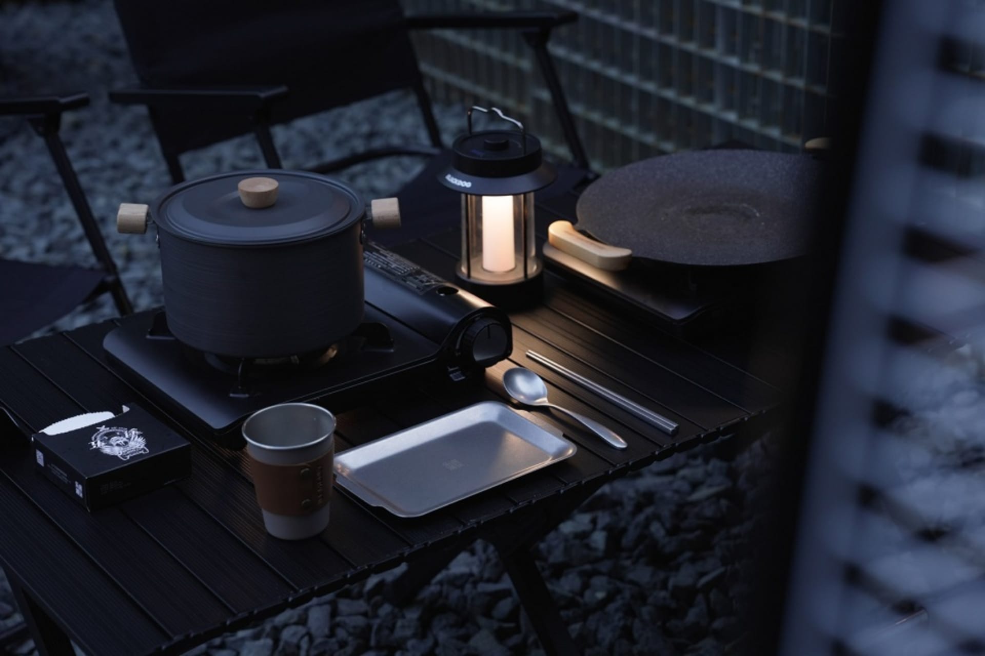 設有木桌的戶外餐飲區，桌上擺放杯子、湯匙與碗盤，營造輕鬆休閒氛圍