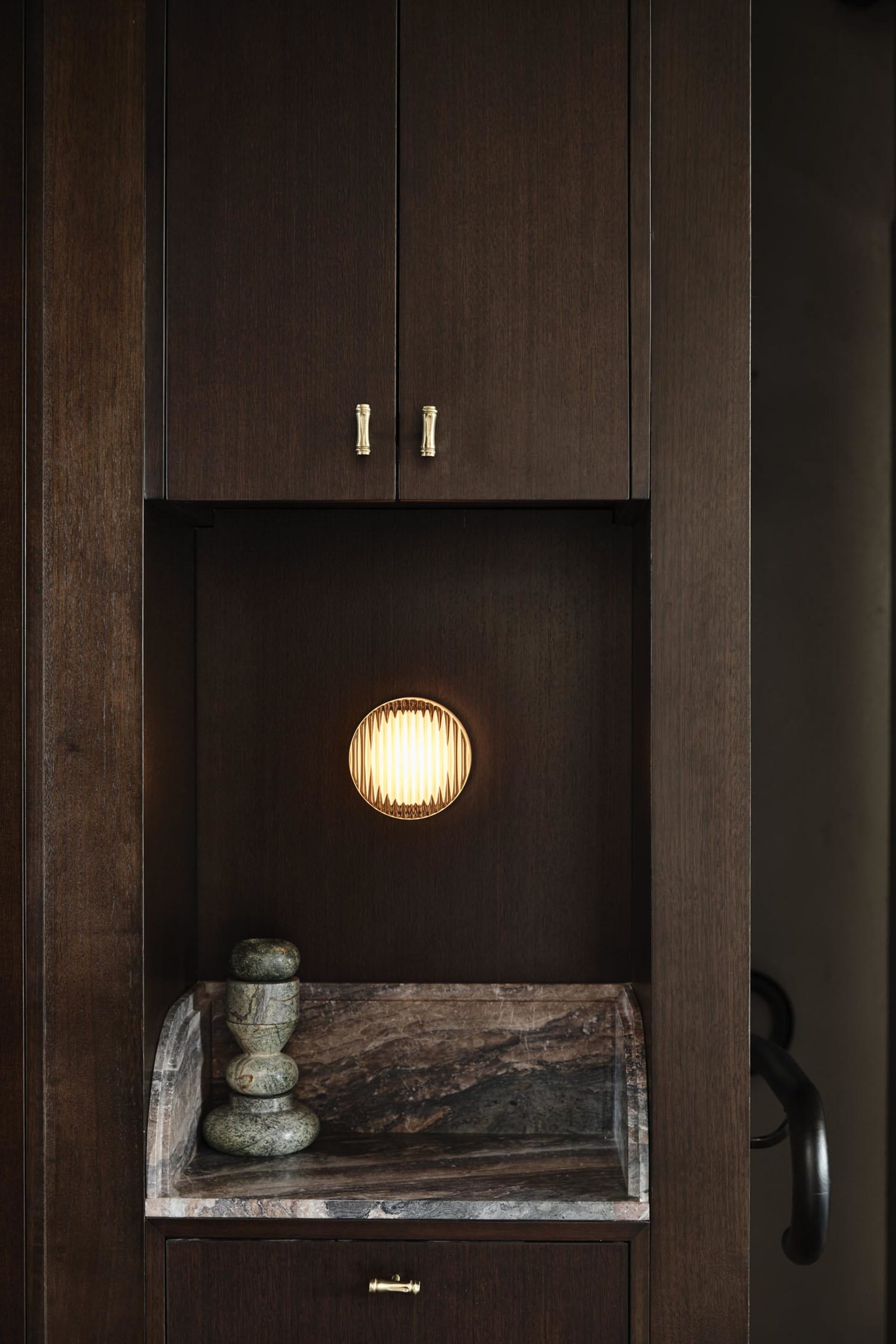 A wooden kitchen cabinet with a light on inside, creating a warm atmosphere
