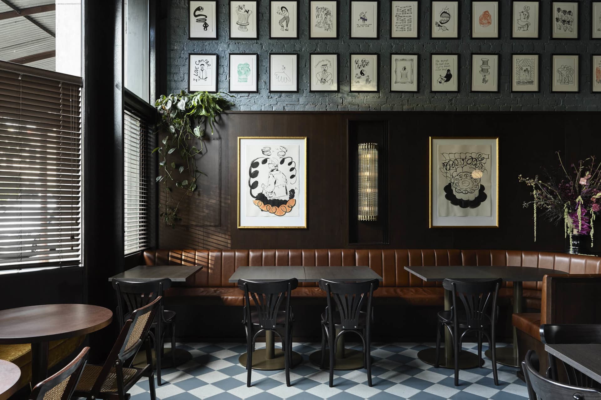A restaurant dining area with multiple tables and chairs, walls adorned with pictures, creating an inviting atmosphere for meals and socializing