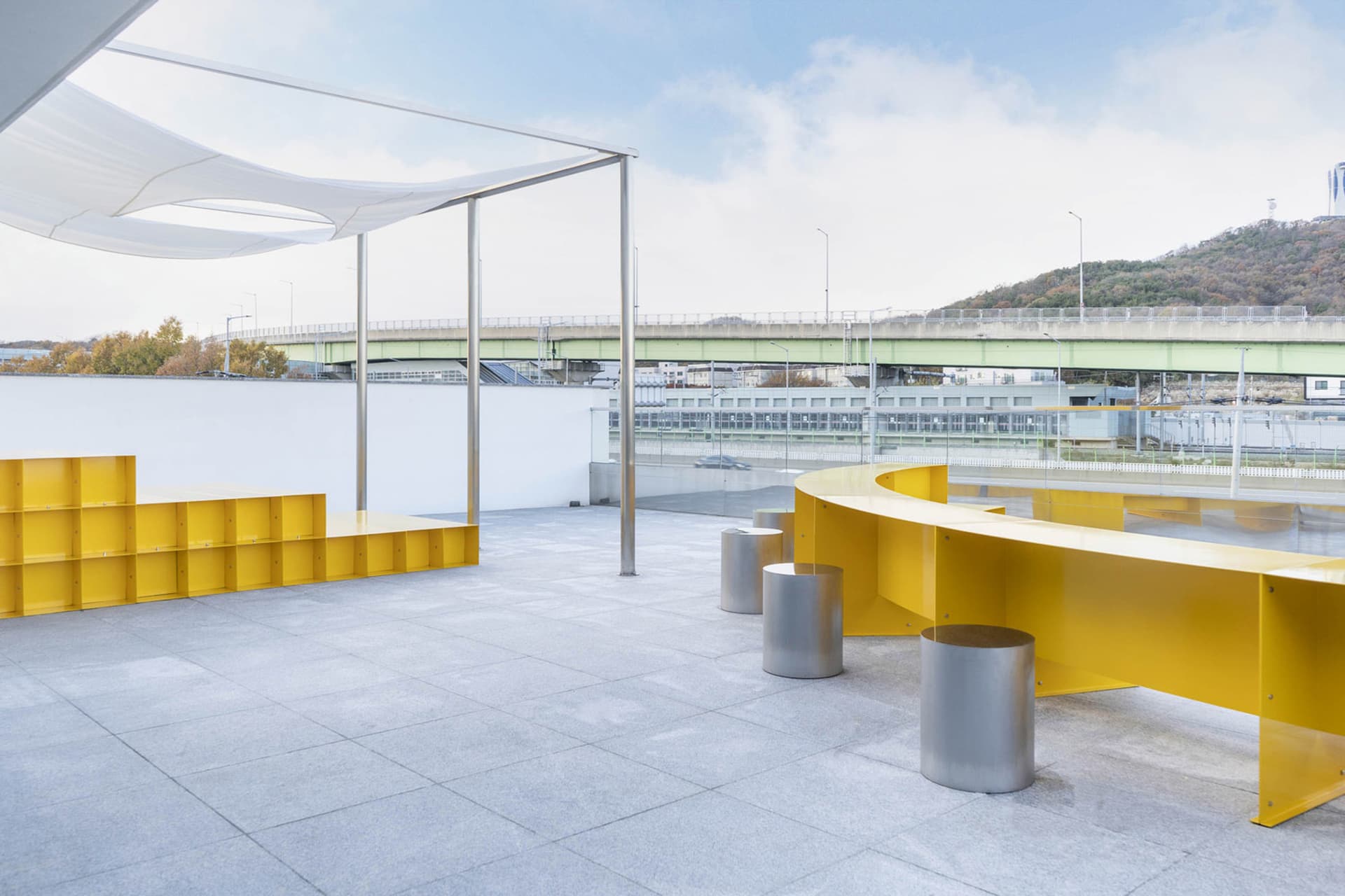 A cozy open area with a wooden table surrounded by metal stools and a bench, creating a comfortable seating space
